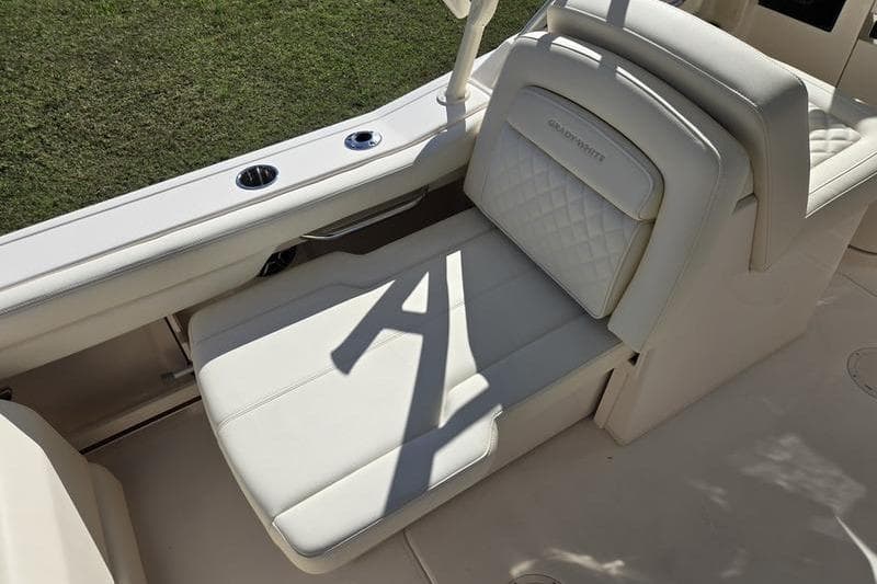 2026 Grady-White Freedom 235 boat seat with elegant white upholstery and cup holders.