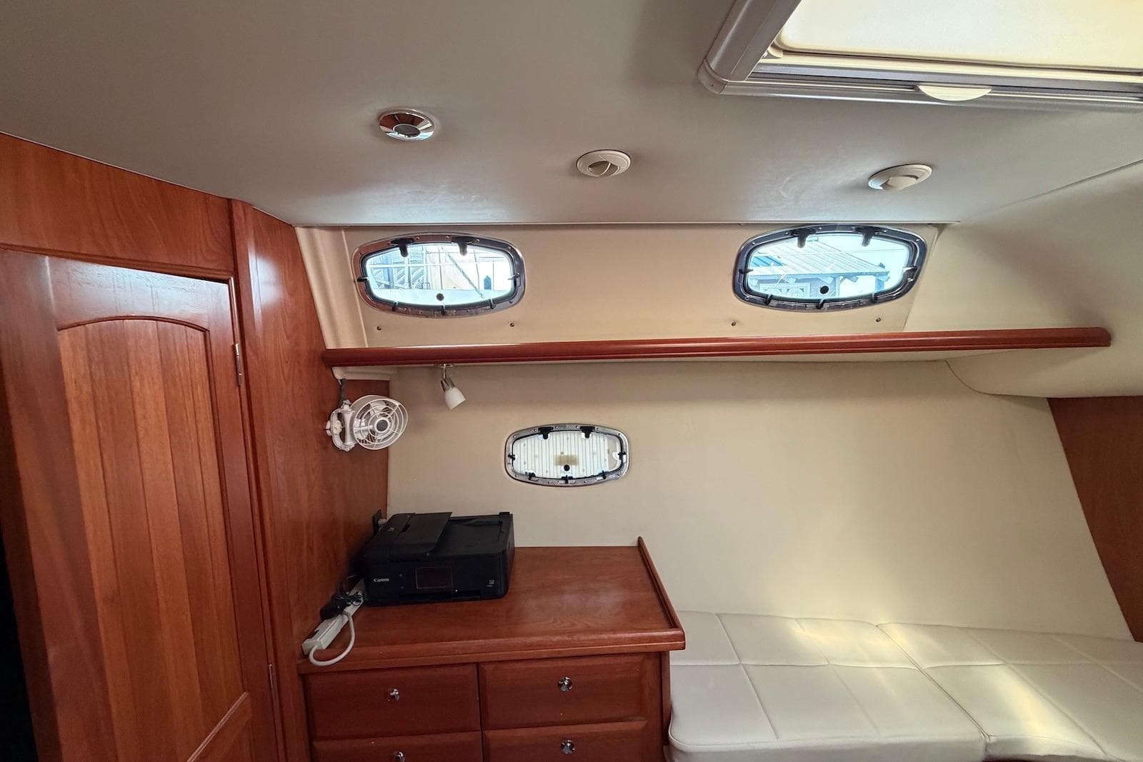Interior of 2009 Hunter 50 Center Cockpit yacht with wood cabinetry and porthole windows.