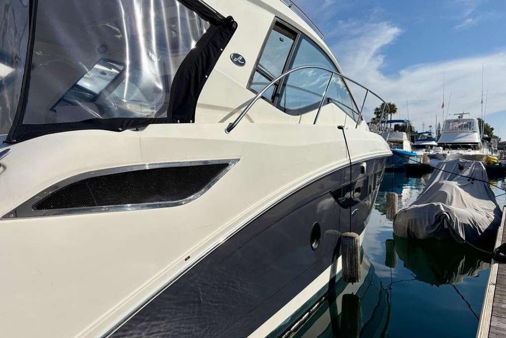 2018 Sea Ray Sundancer 350 Coupe docked at marina under clear sky.
