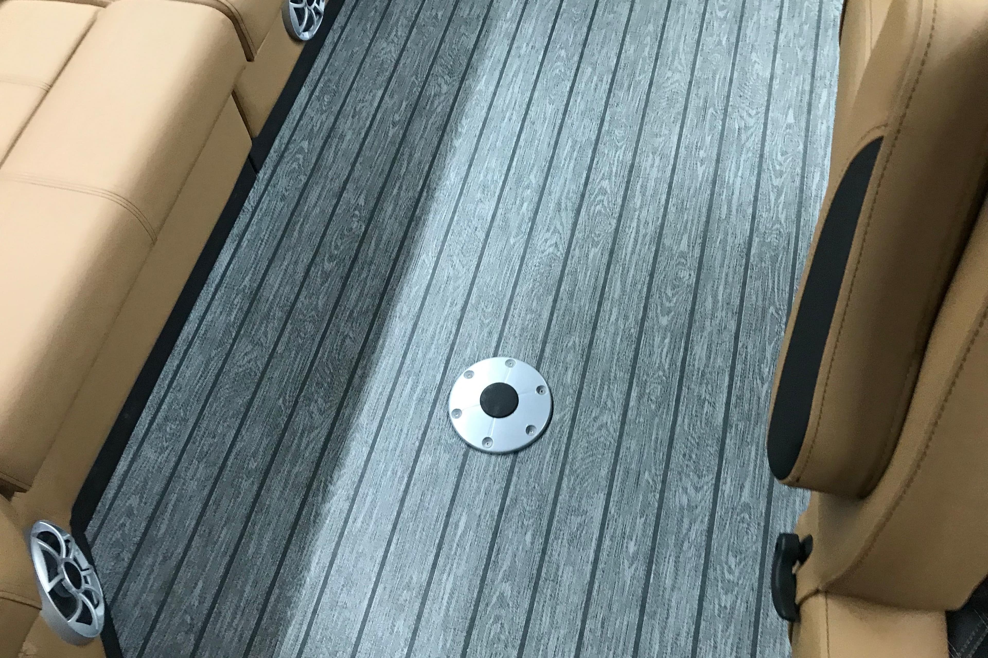 2026 Ranger Reata 220FC interior with gray flooring and tan seating.