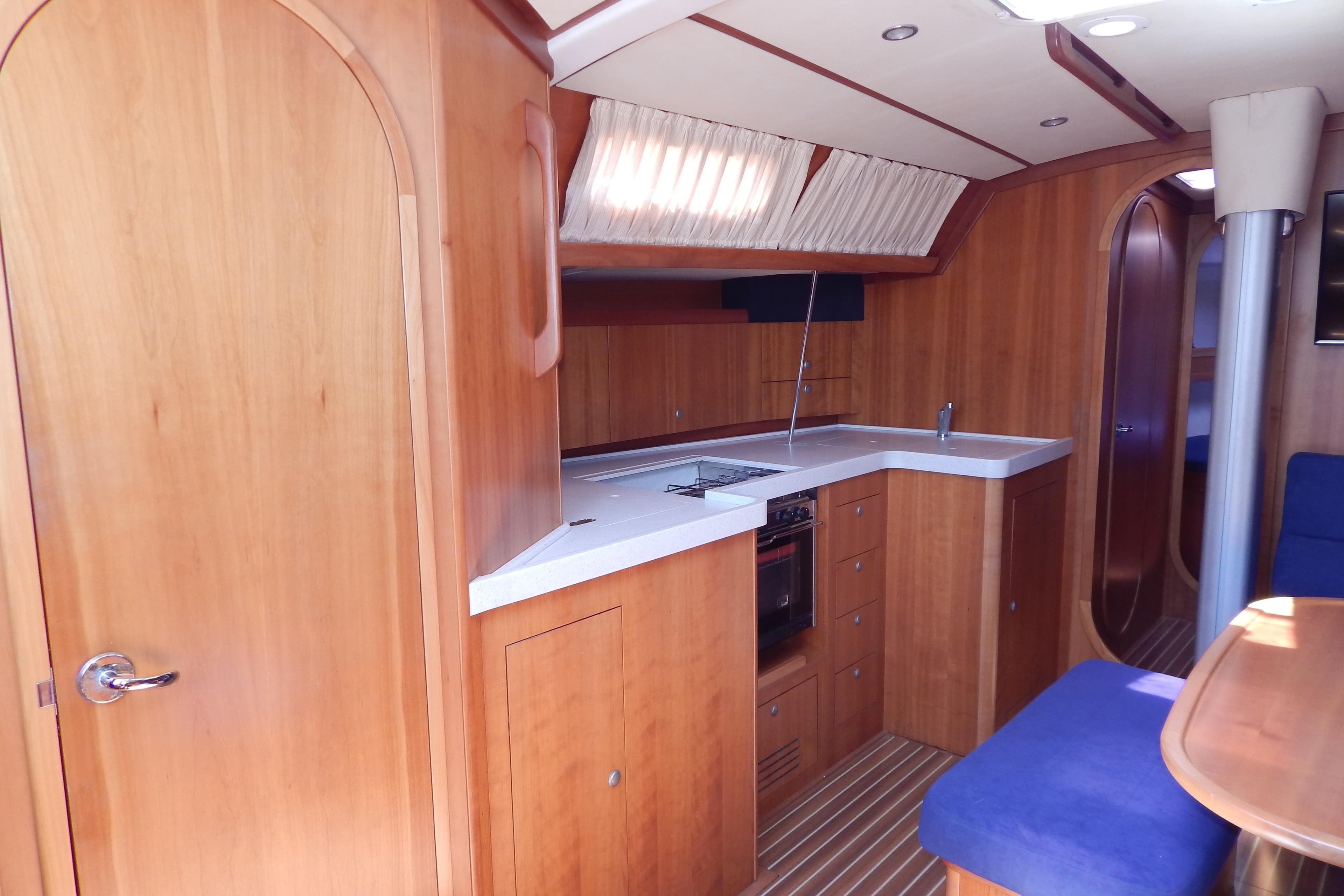 Interior of 2006 Salona 45 yacht by AD BOATS LTD, featuring a wooden kitchen and seating area.