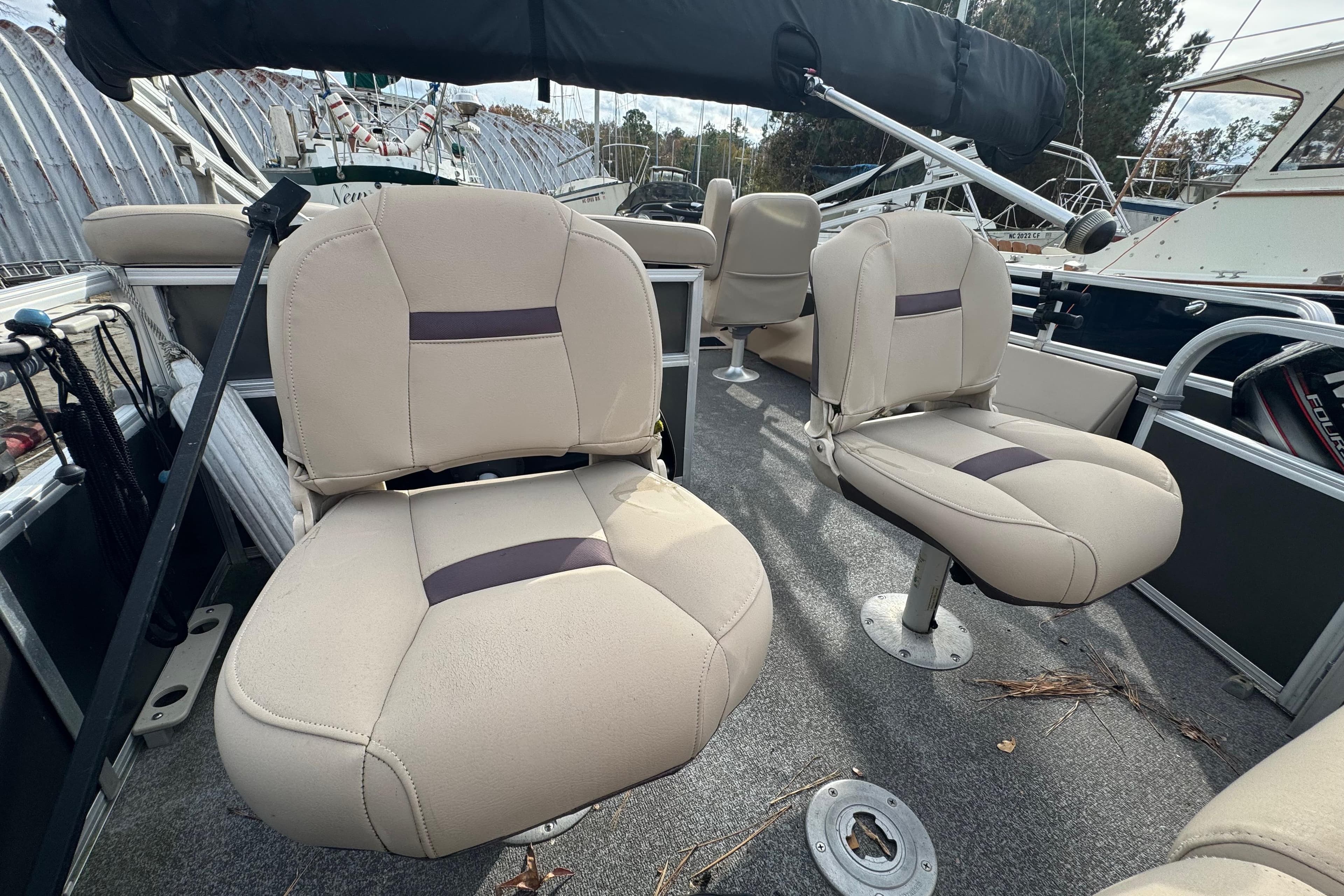 2017 SUNTRACKER TRI-TOON boat interior with beige seating & bimini top