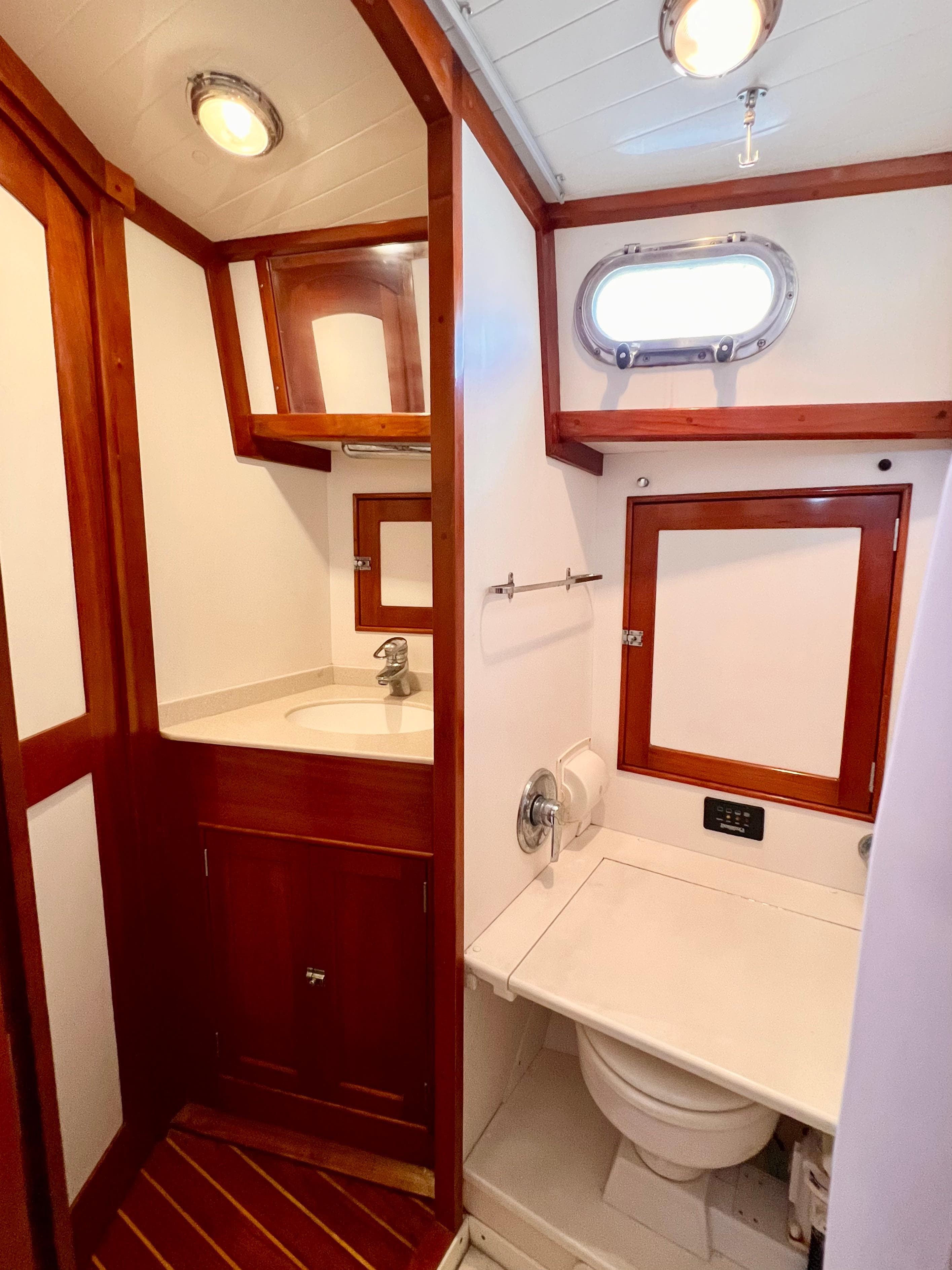 2001 Shannon 43 Cutter bathroom with wood accents, sink, and porthole window.