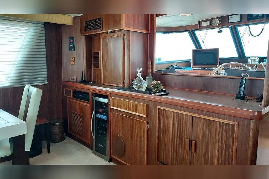 Interior of 1983 Hatteras 53 Extended Deckhouse Motor Yacht with wood cabinetry and dining area.