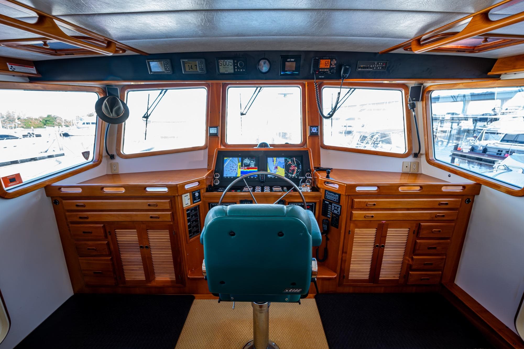 Pilothouse interior of 2006 Krogen 58 yacht with navigation equipment and wooden cabinetry.