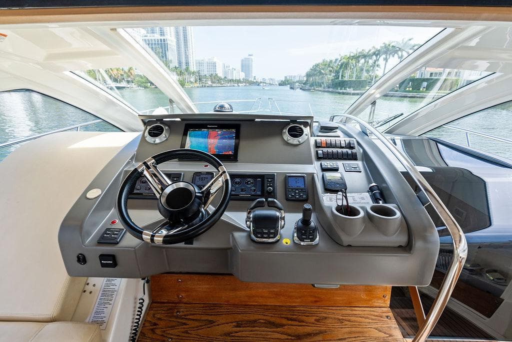 Helm of 2014 Cranchi 56 HT yacht with modern navigation equipment and waterfront view.