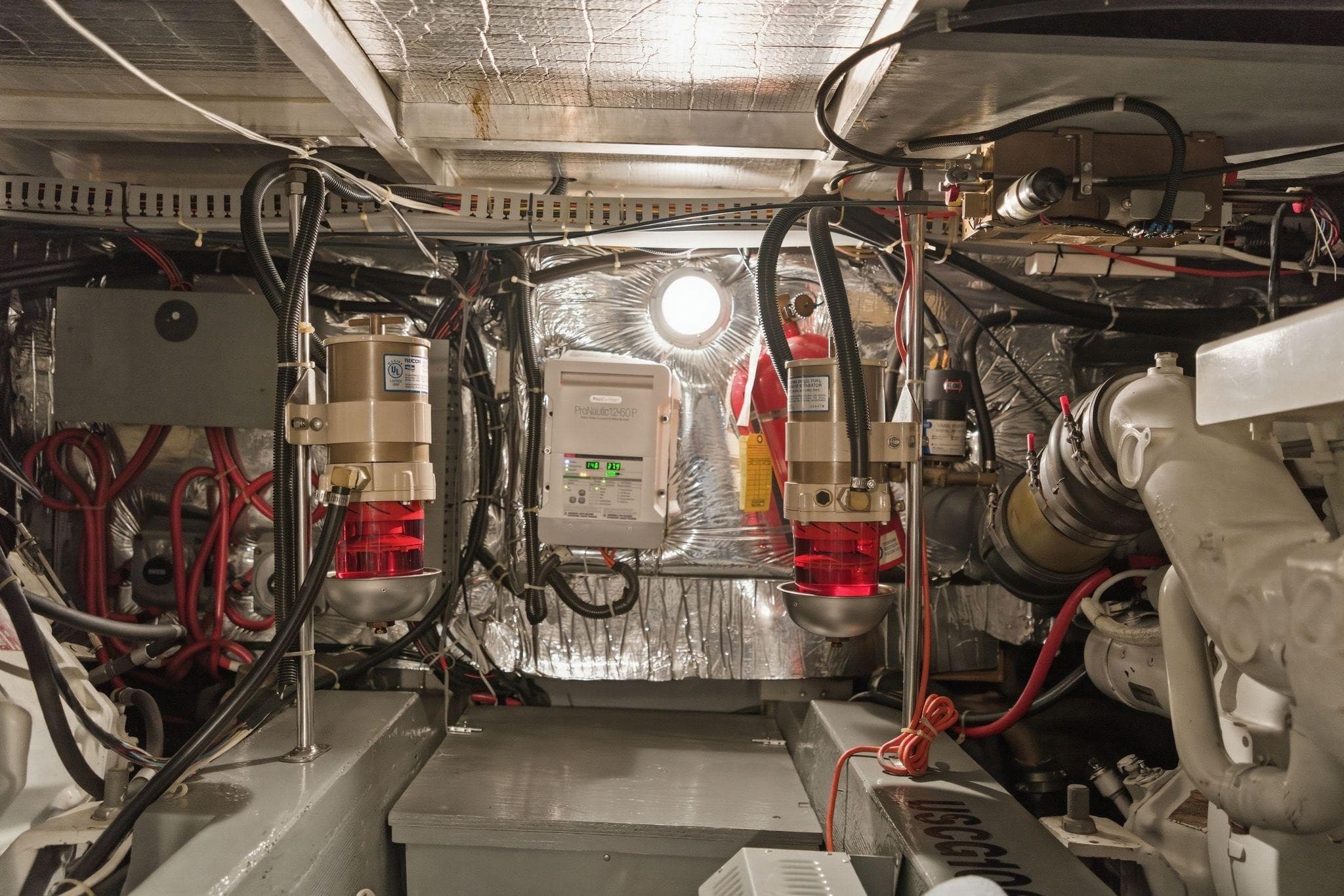 Engine room of a 1998 Carver 445 Aft Cabin Motor Yacht, showcasing mechanical components.