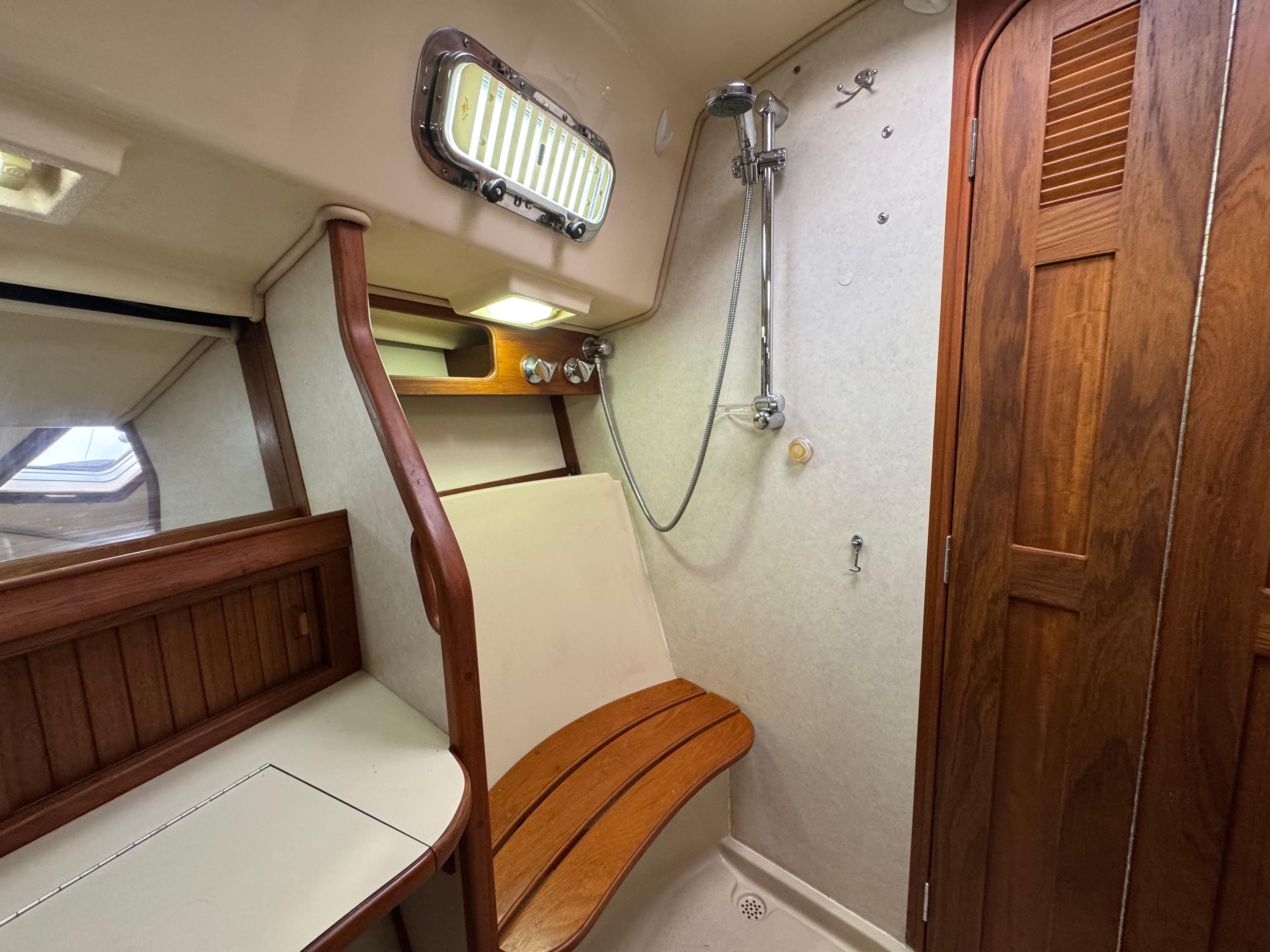 1999 Island Packet 45 yacht bathroom with wooden accents and shower.