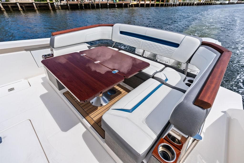 Luxurious seating area on 2021 Tiara Yachts 43 LS with elegant wooden table.
