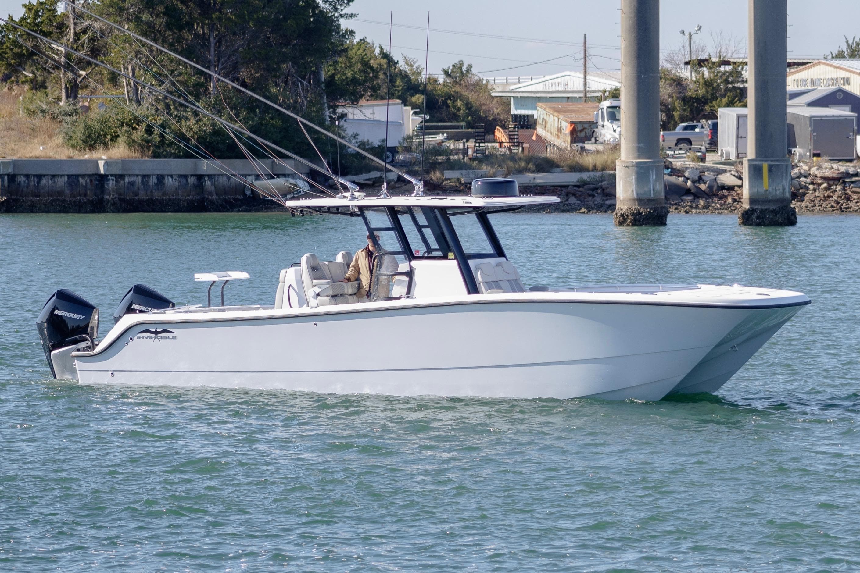2022 Invincible 33 Catamaran cruising on water near docks.