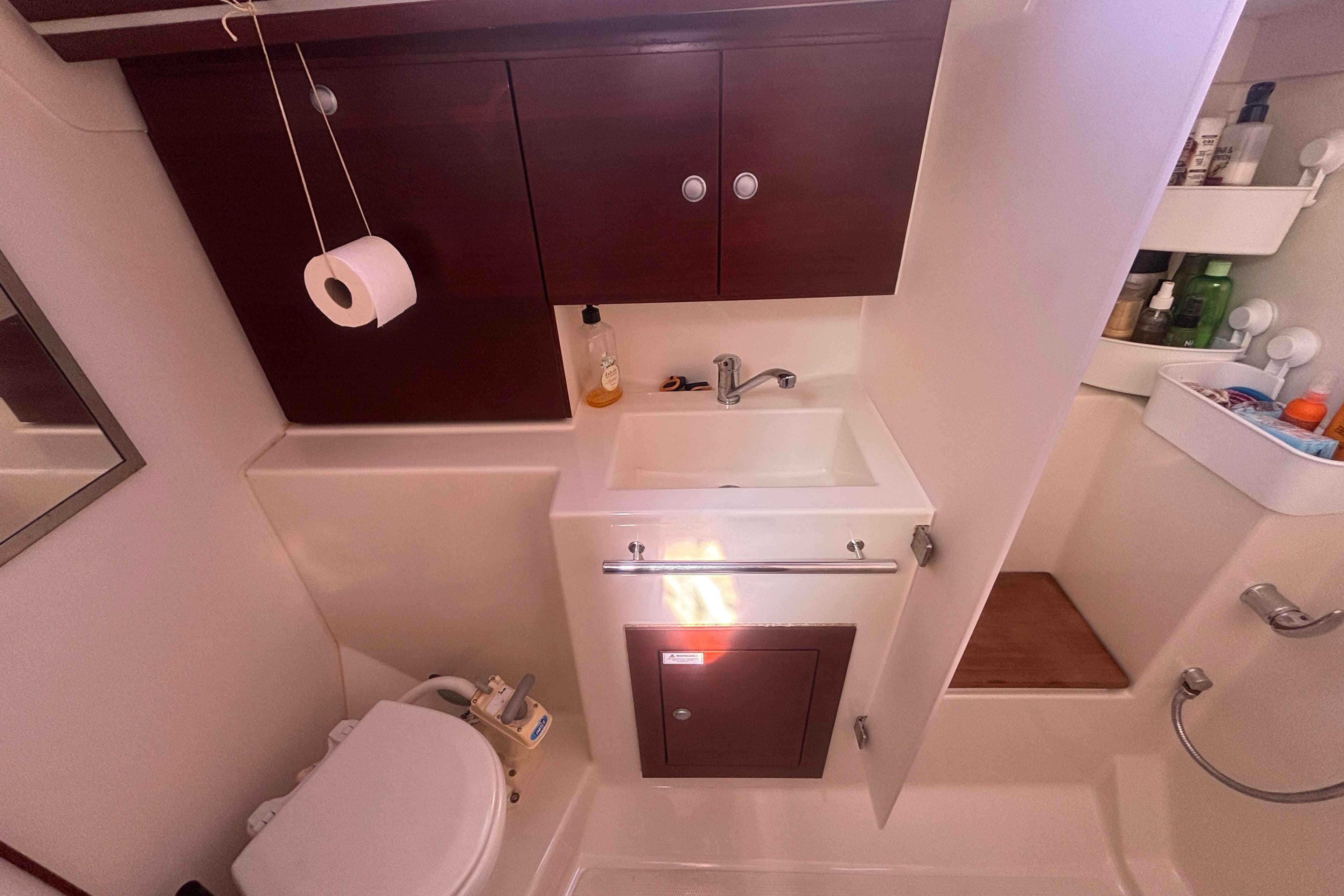Compact bathroom in a 2008 Hanse 370 yacht with sink, toilet, and storage cabinets.