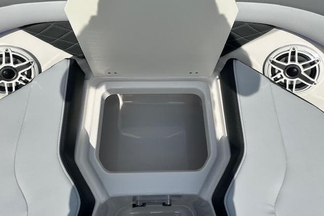 2026 Chaparral 6 SSX boat interior storage compartment with speakers and cushioned seating.