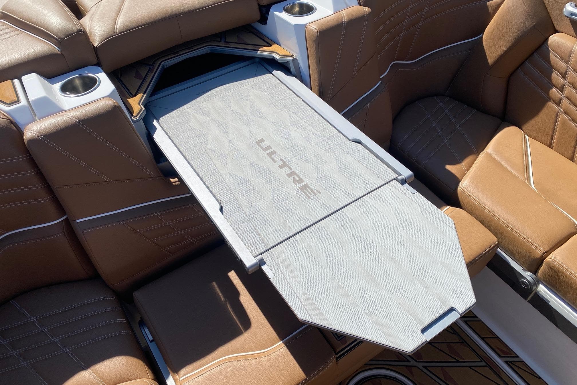 2025 Tigé Ultré 25ZX boat interior with brown leather seating and foldable table.