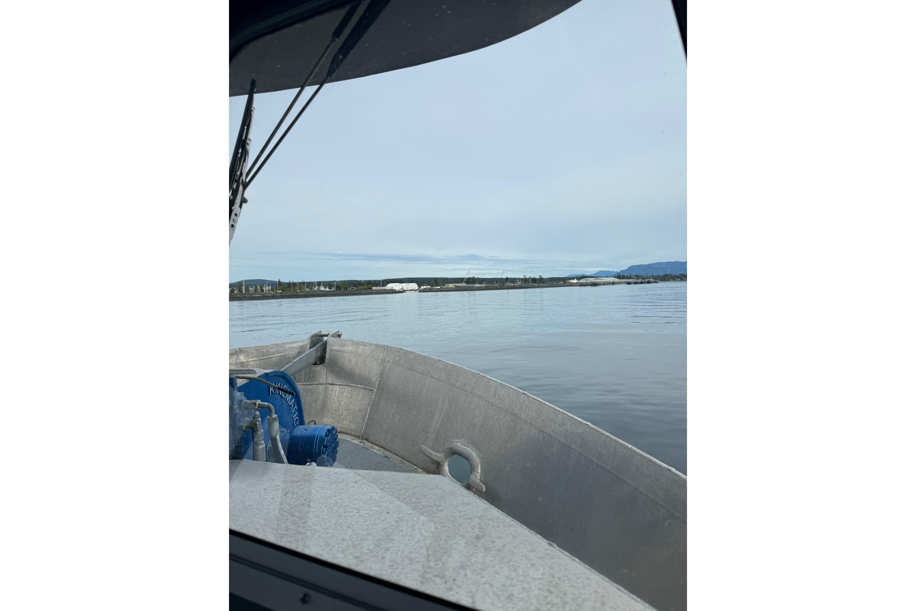 Custom 2021 Aluminum Crabber boat on calm waters with distant shoreline view.