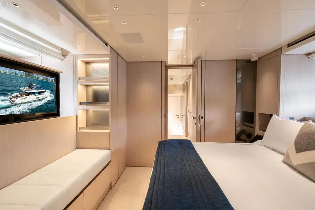 Luxurious interior of 2021 Sanlorenzo SX76 yacht with modern bedroom and TV.