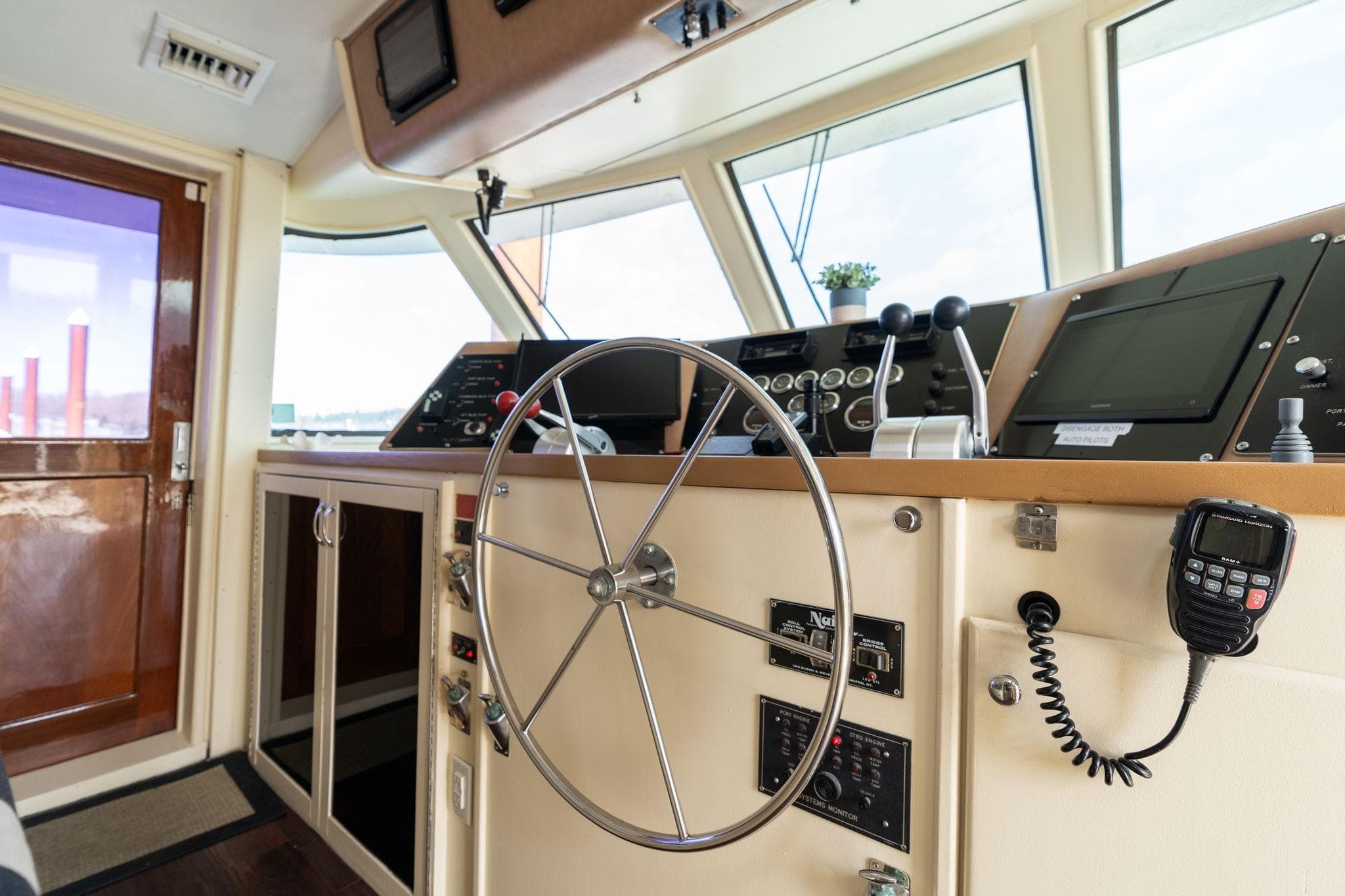 Interior helm of 1986 Hatteras 63 Motor Yacht with steering wheel and navigation controls.