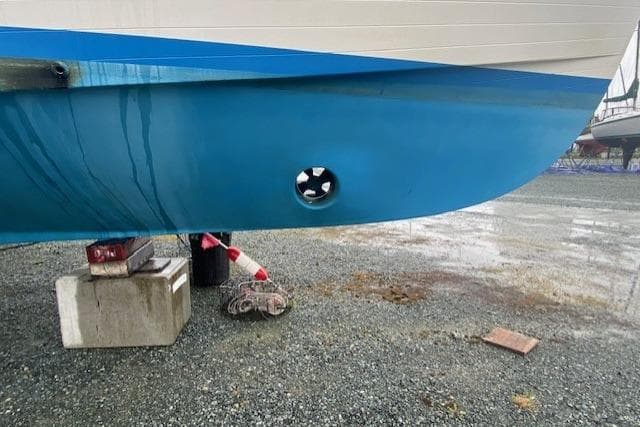 Ocean Alexander 50 Mark I 1980 boat hull with visible thruster on gravel surface.
