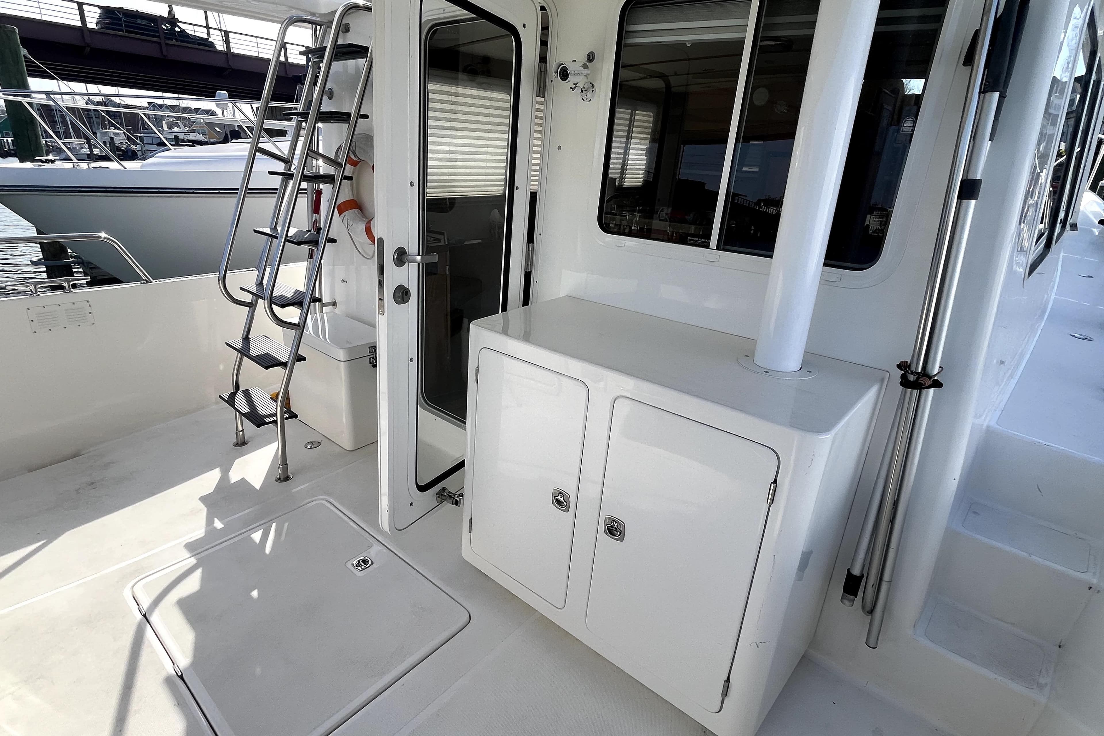 2008 Nordic Tug 42 boat deck with ladder, door, and storage cabinet.
