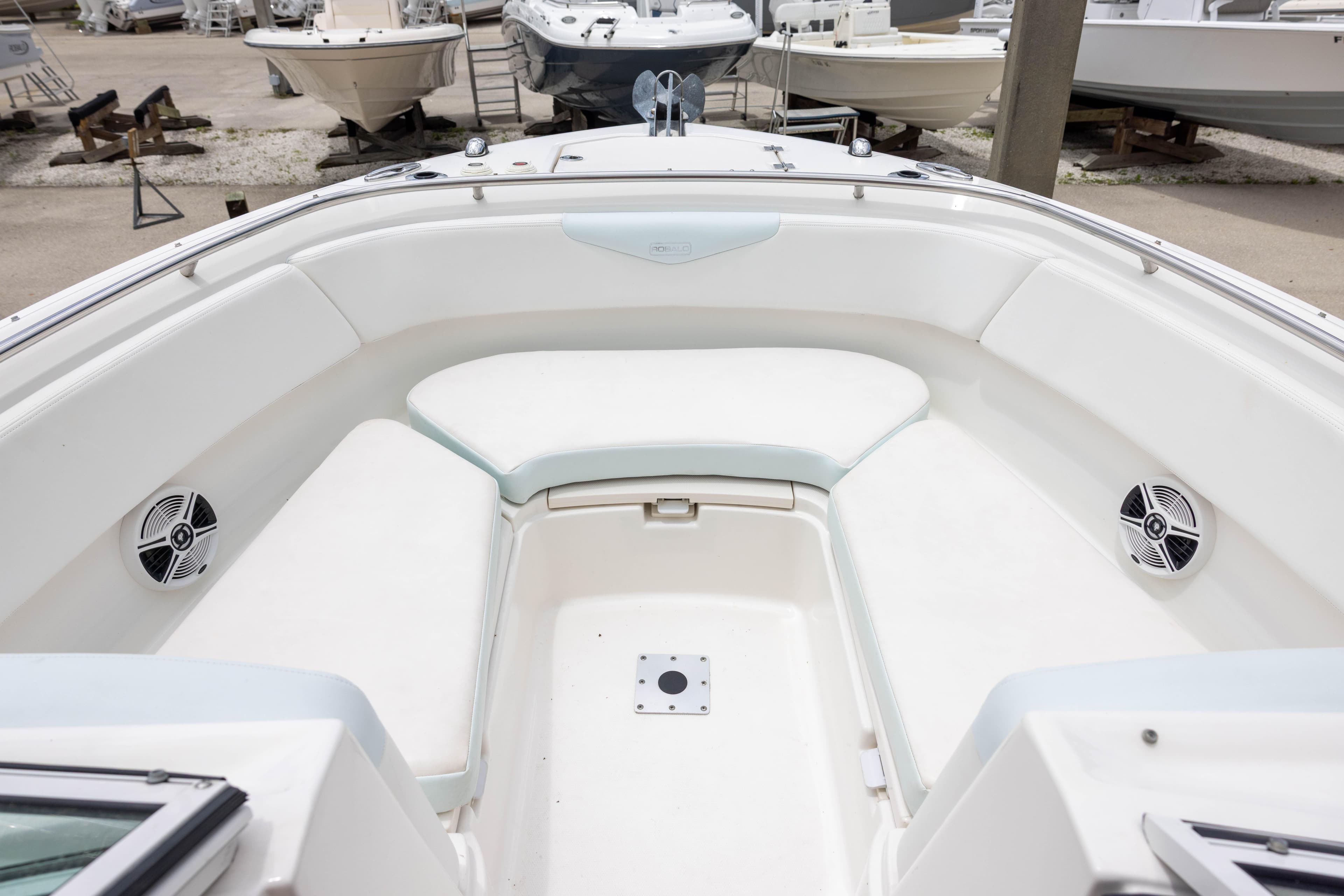 2018 Robalo R247 Dual Console boat interior with white seating and speakers.
