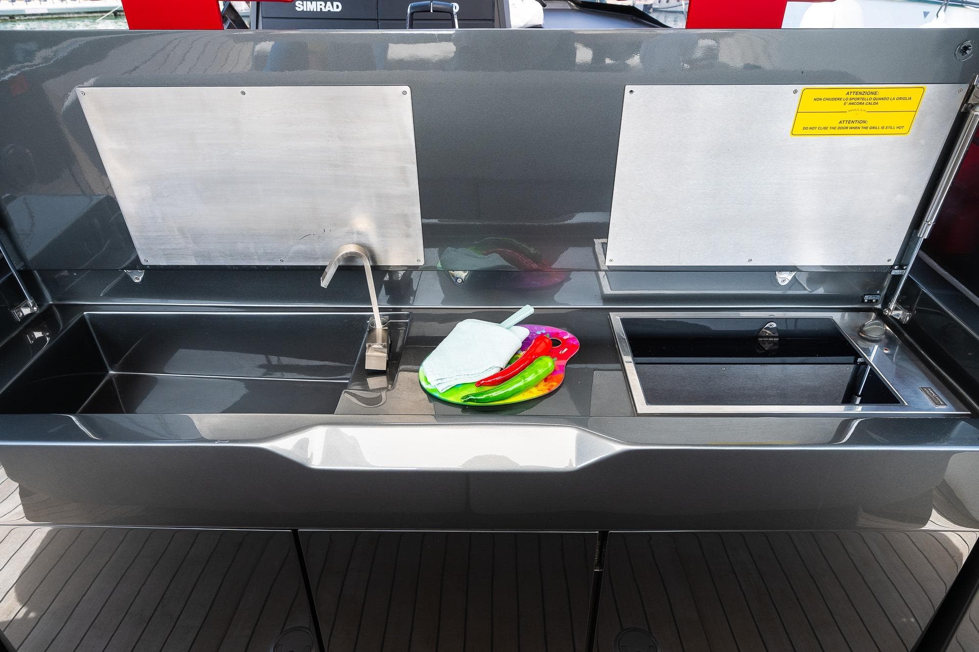 Outdoor kitchen on 2022 Wally Wallytender 48x yacht with sink and colorful utensils.