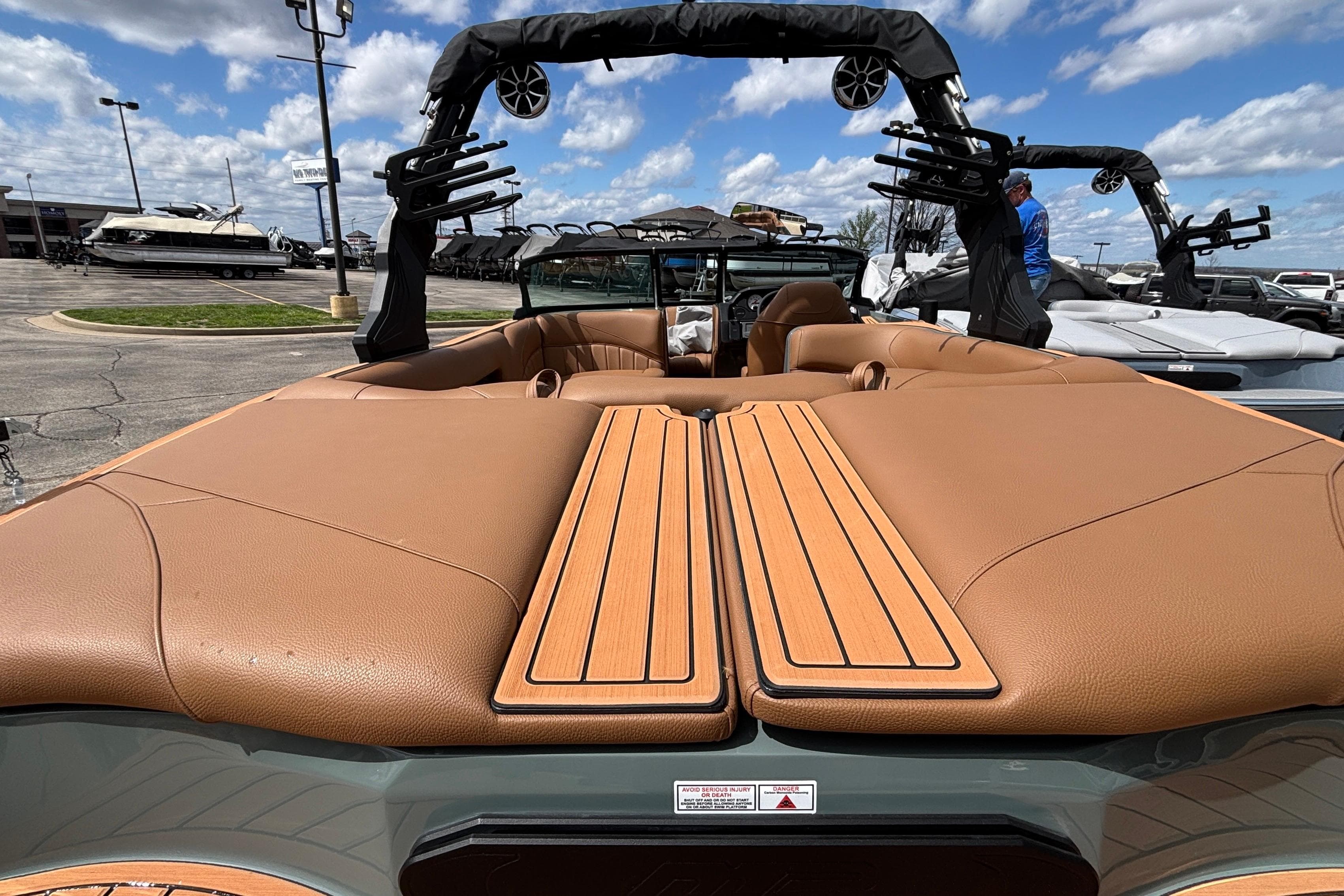 2026 MB B52 23 Classic boat with tan interior, docked under a blue sky.