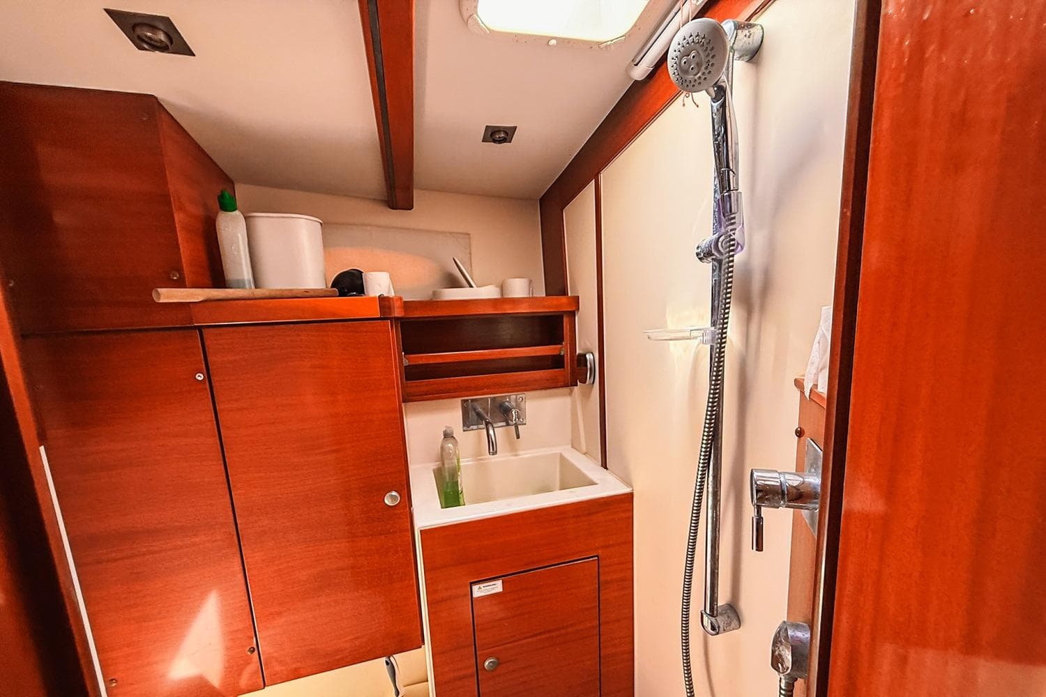 Interior of 2004 Hanse 531 yacht bathroom with wooden cabinets and shower.