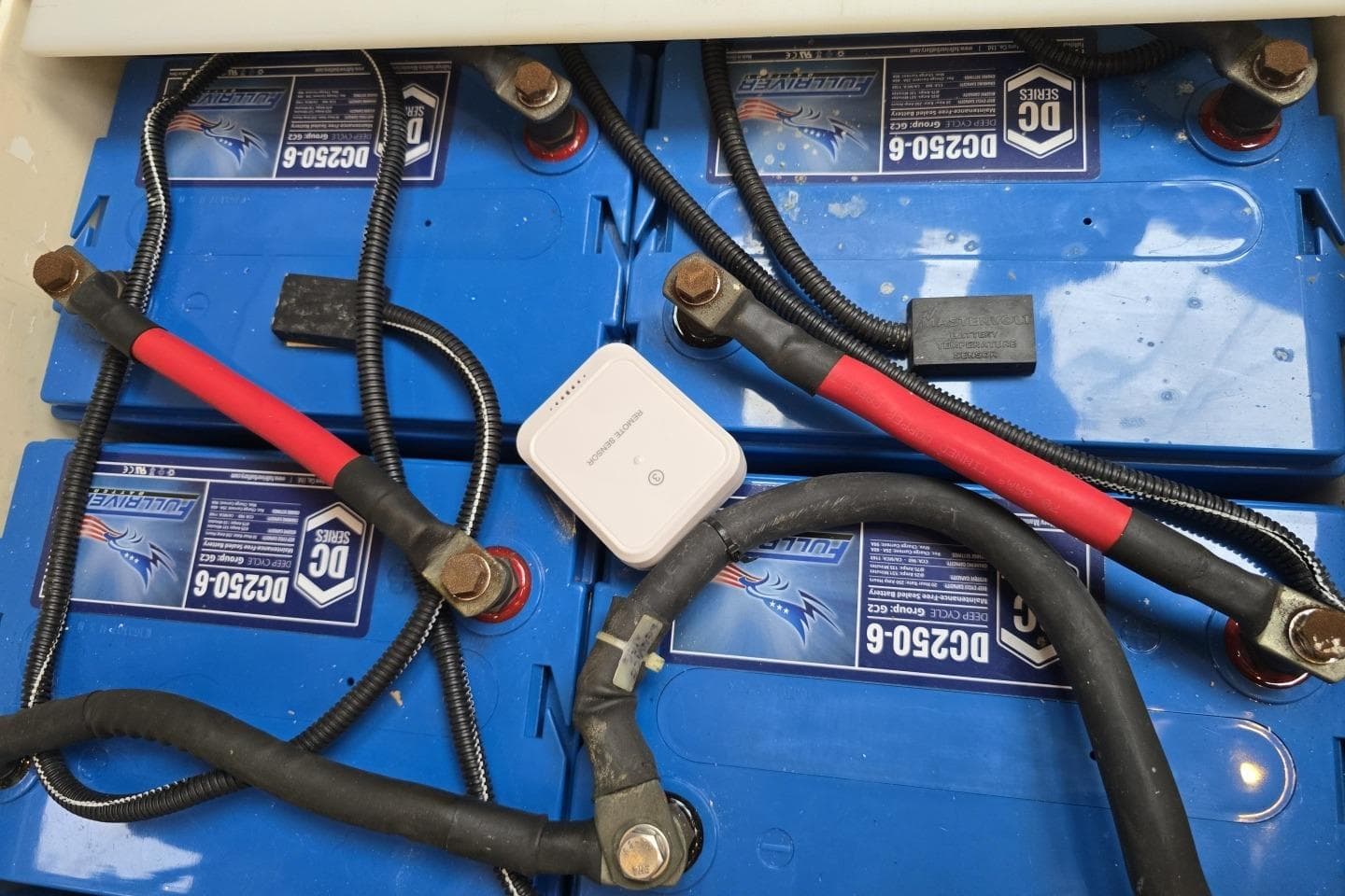 Battery compartment of a 2005 Oyster 56 yacht with connected cables.