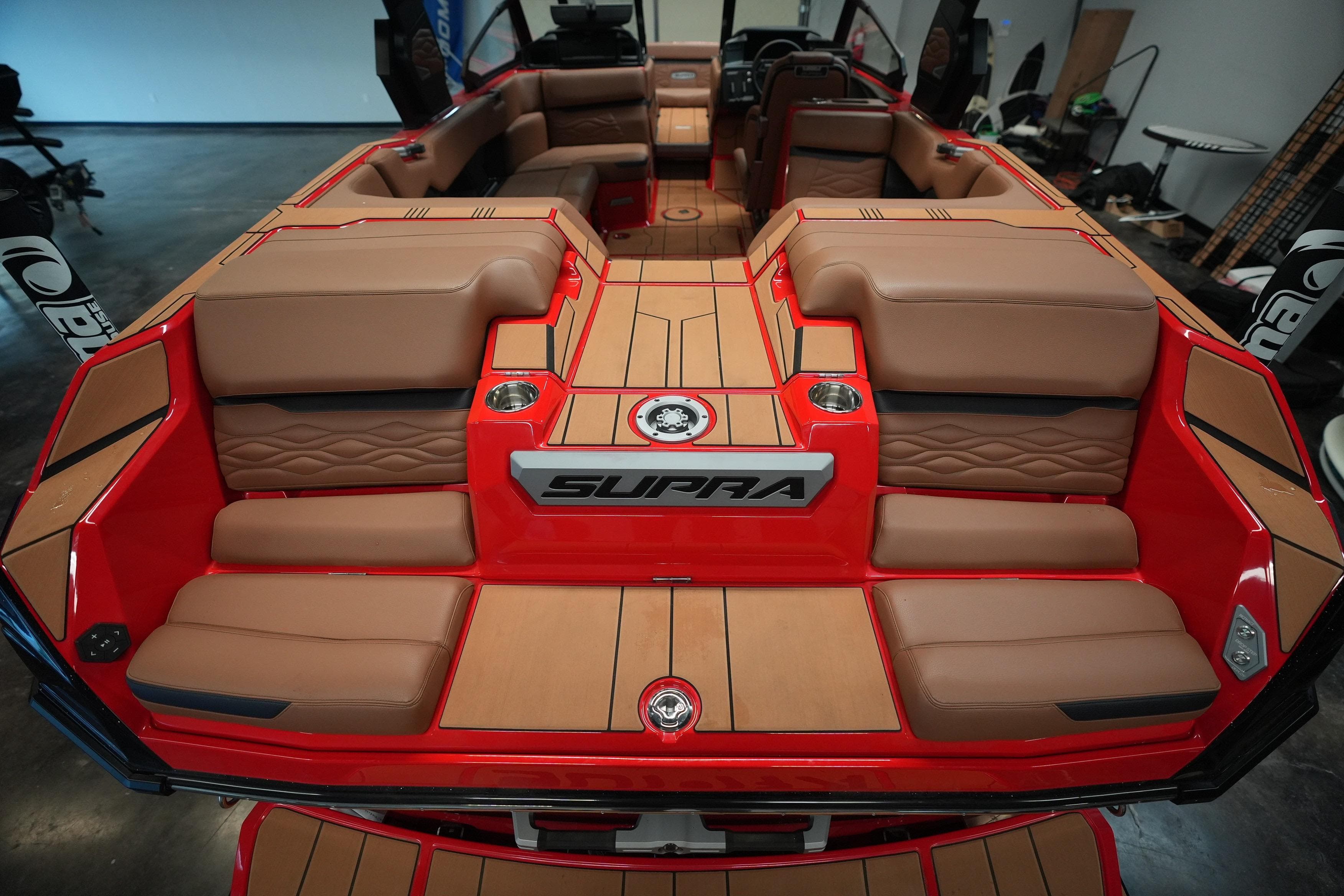 2026 Supra SA boat interior with luxurious tan seating and red accents.