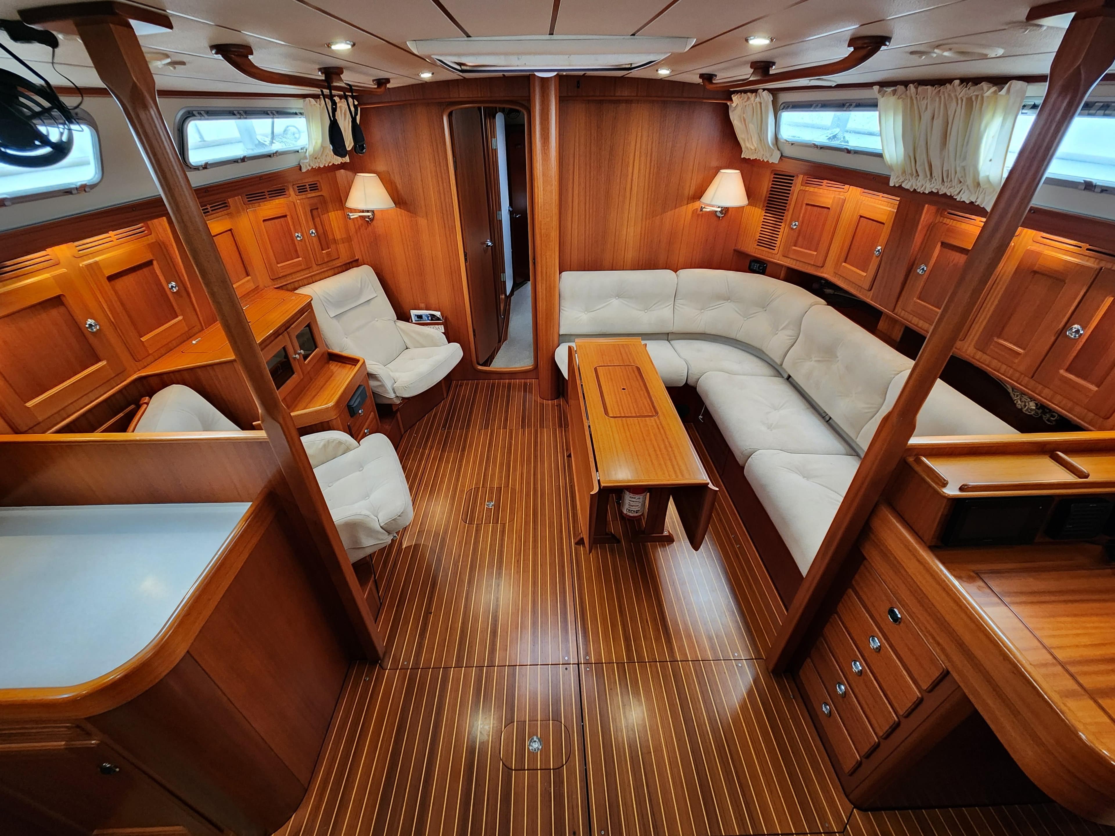 Luxurious 2009 Hallberg-Rassy 54 yacht interior with elegant wood finish and comfortable seating.