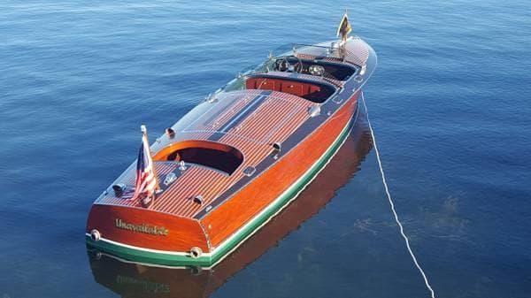 1989 Hacker-Craft Triple Cockpit boat on calm water, showcasing classic wooden design.