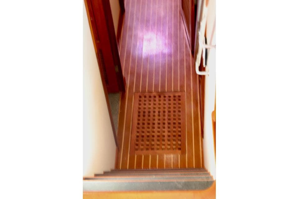 Wooden interior flooring of a 1996 Nordhavn 46 yacht, featuring a grated section.