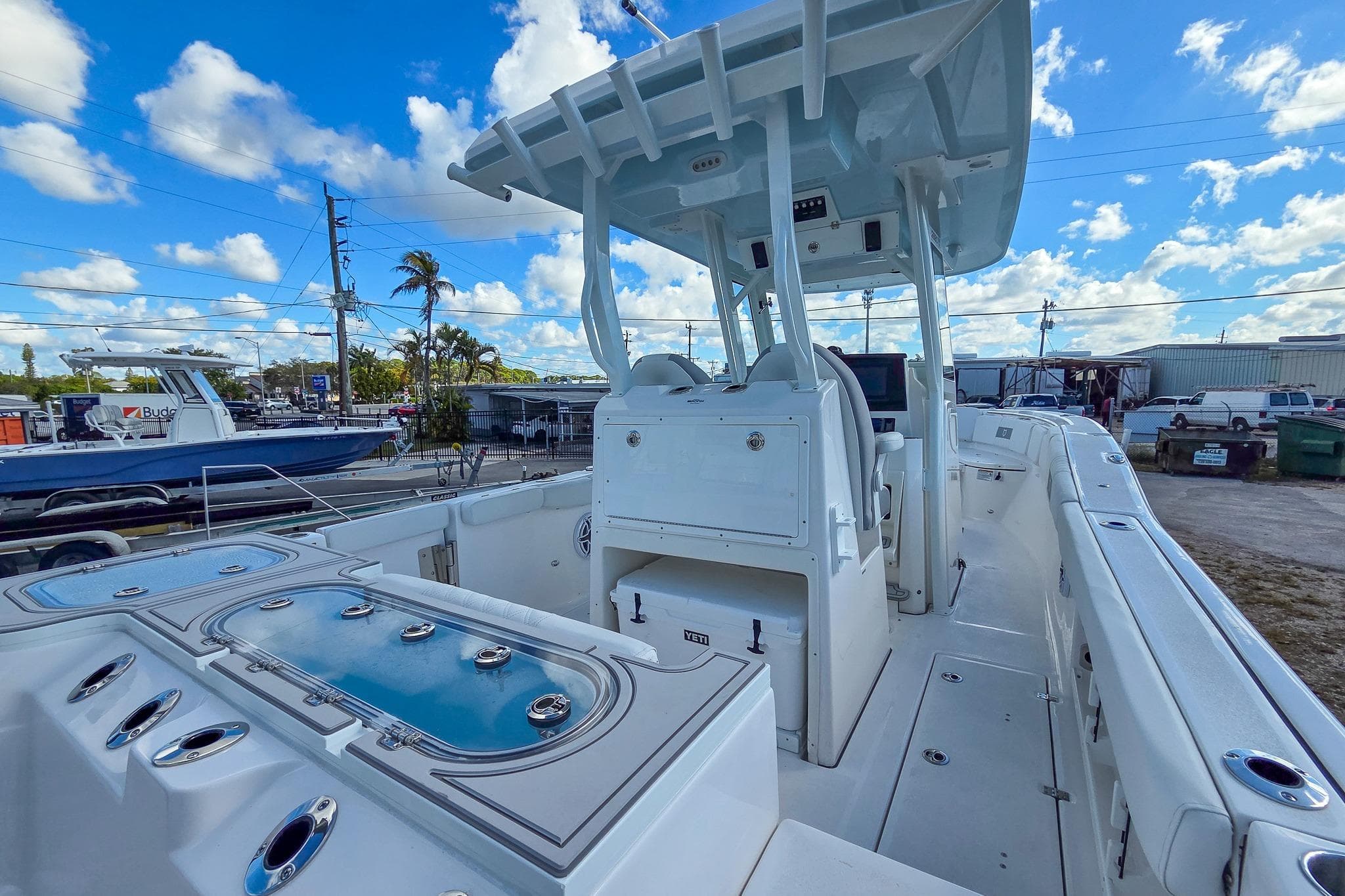 2026 Sea Fox 288 Commander boat interior with seating and storage, under a clear blue sky.