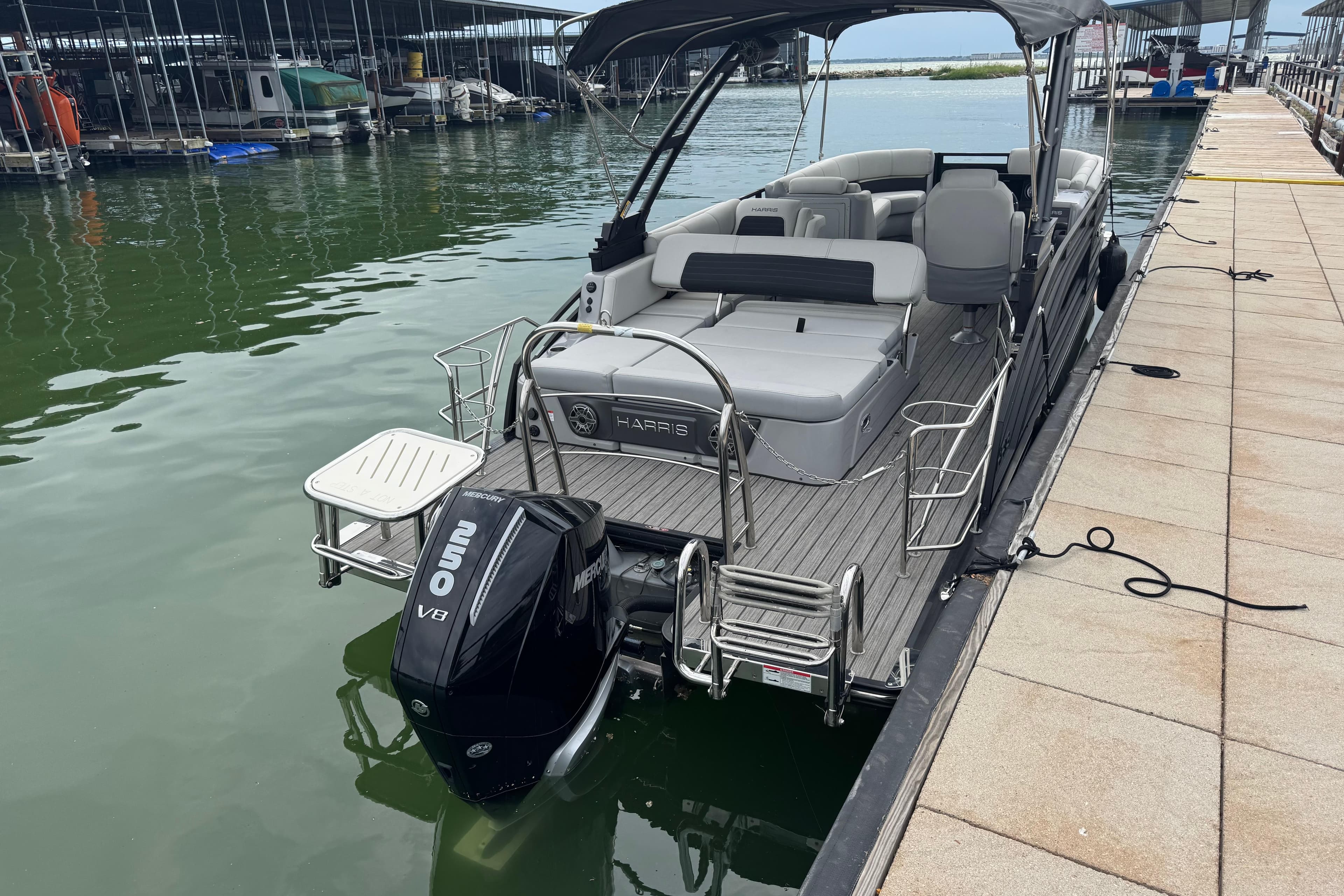 2023 Harris Solstice 230 pontoon boat docked with Mercury 250 V8 engine.