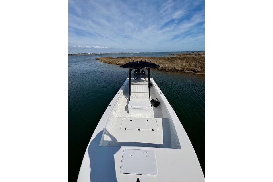 2025 C-Hawk 26 Center Console boat on calm water under blue sky.