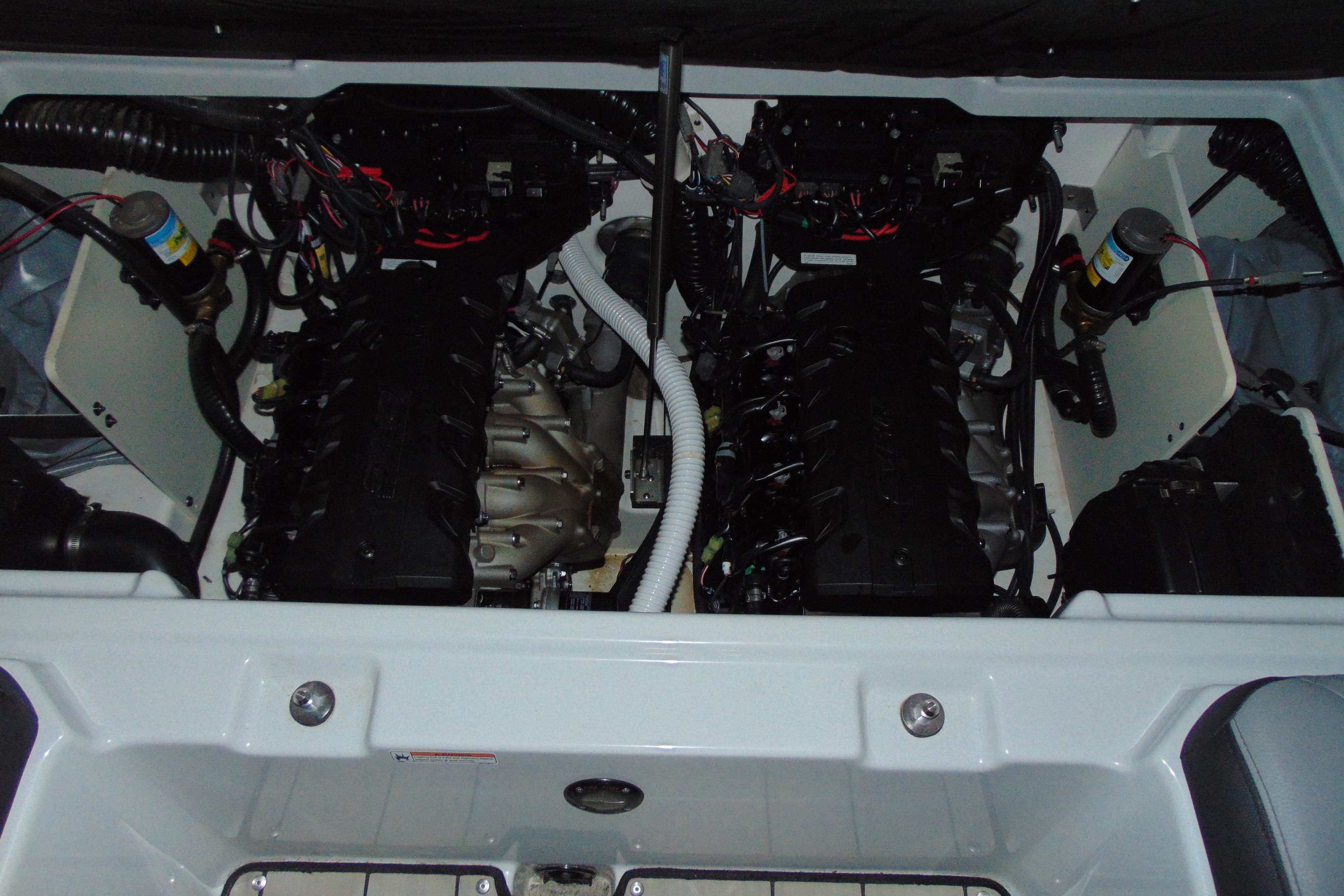 Engine compartment of 2024 Yamaha Boats 255XD, showcasing dual engines and wiring.