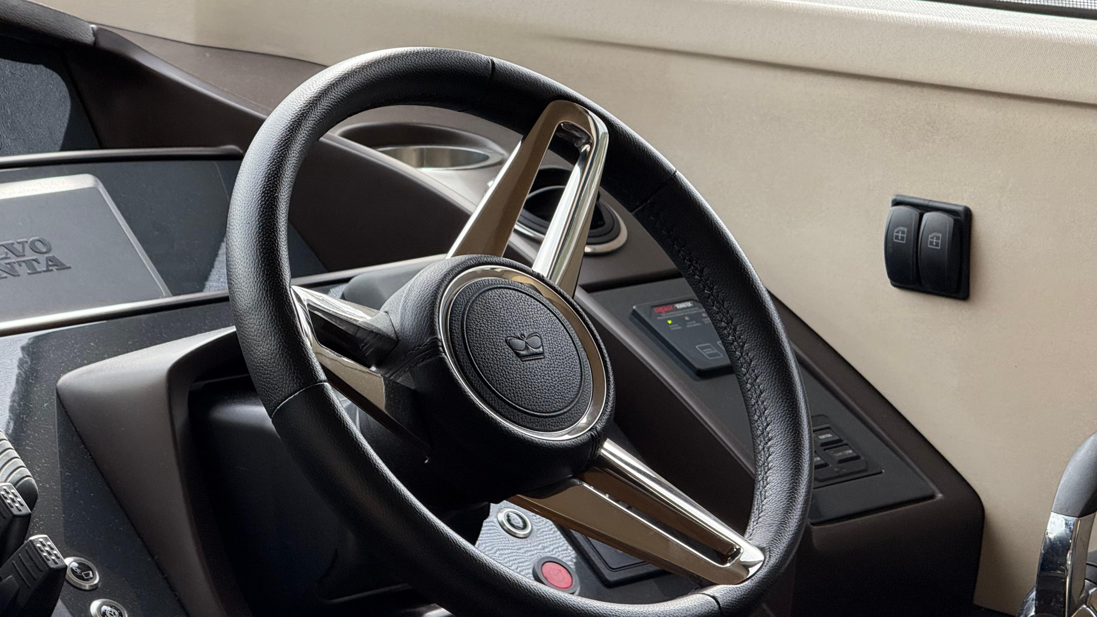 Steering wheel of a 2016 Princess 56 yacht, featuring modern controls and Volvo Penta branding.