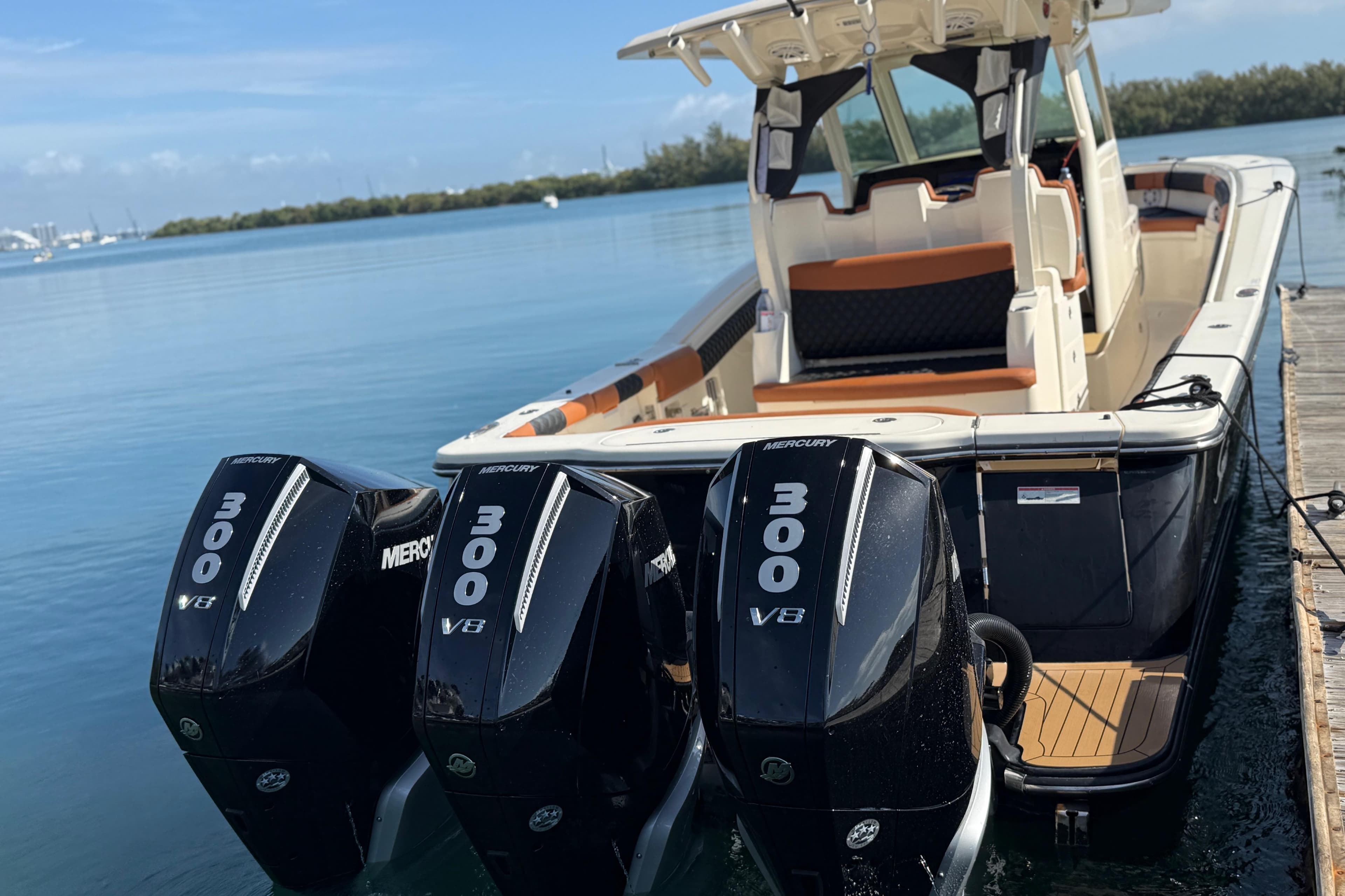 2019 Scout 355 LXF boat with triple Mercury 300 V8 engines docked by the water.