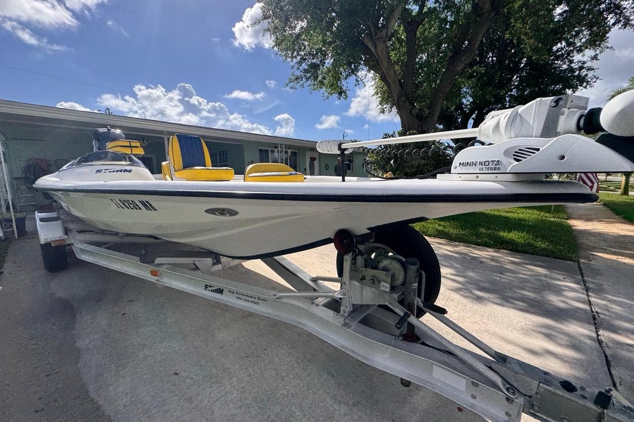 2005 Storm Boats Storm-High Performance on trailer, featuring Minn Kota Ulterra motor, parked outdoors.