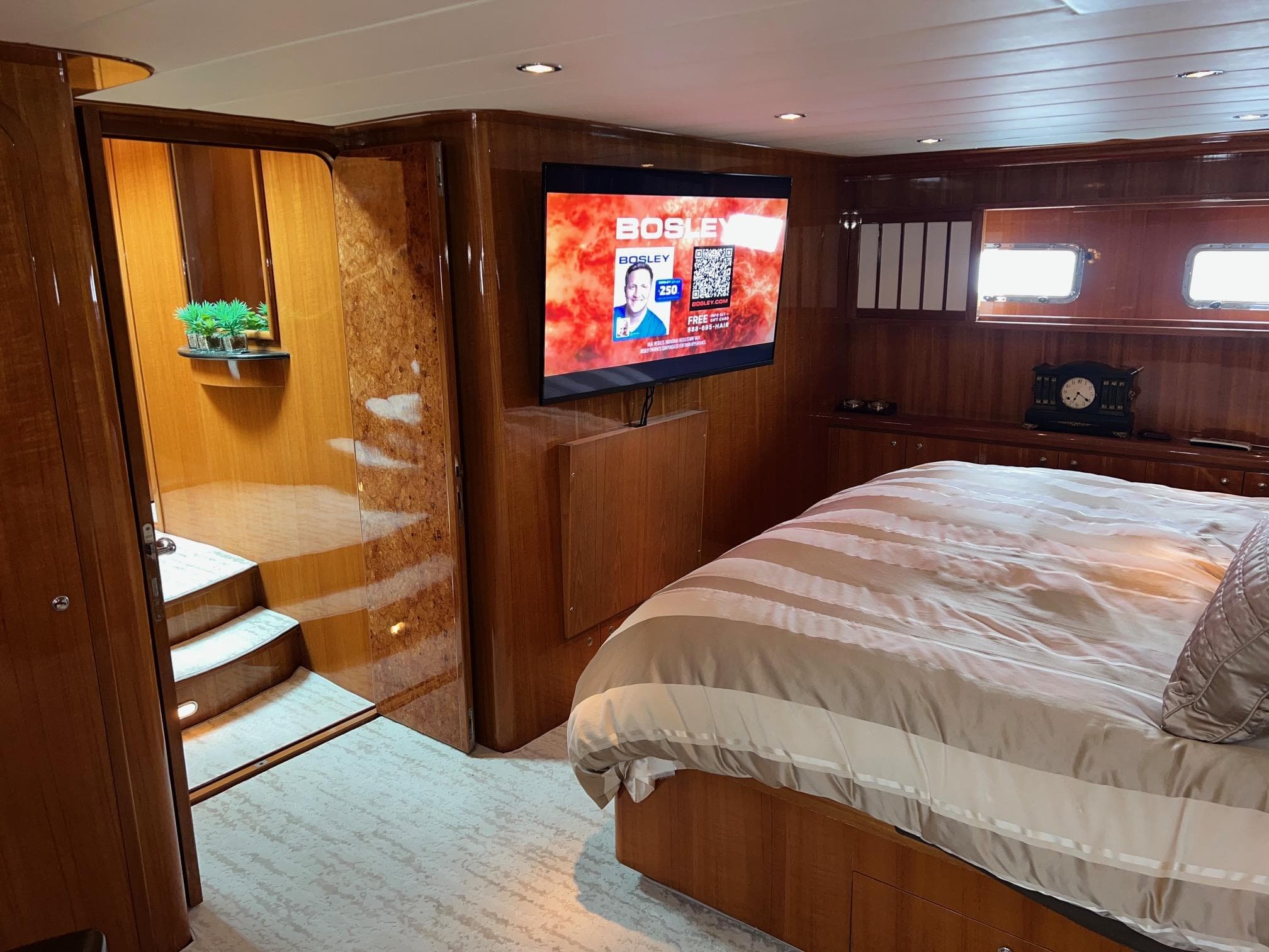 Luxurious 2001 Horizon Skylounge yacht bedroom with TV, wooden decor, and cozy bedding.