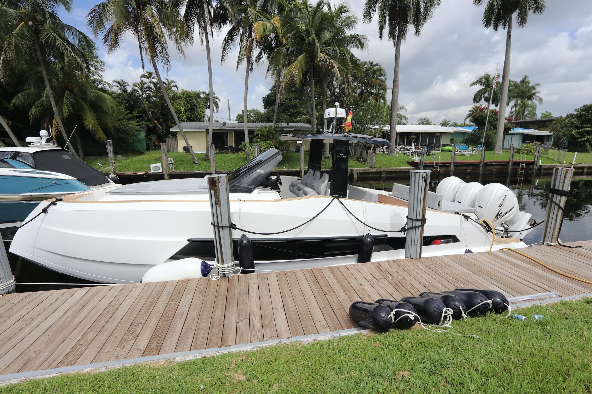 2024 Astondoa 377 Coupe Outboard docked by palm trees.