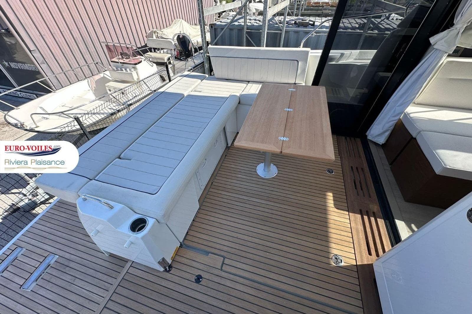 2024 Jeanneau NC 37 boat deck with seating and wooden table.