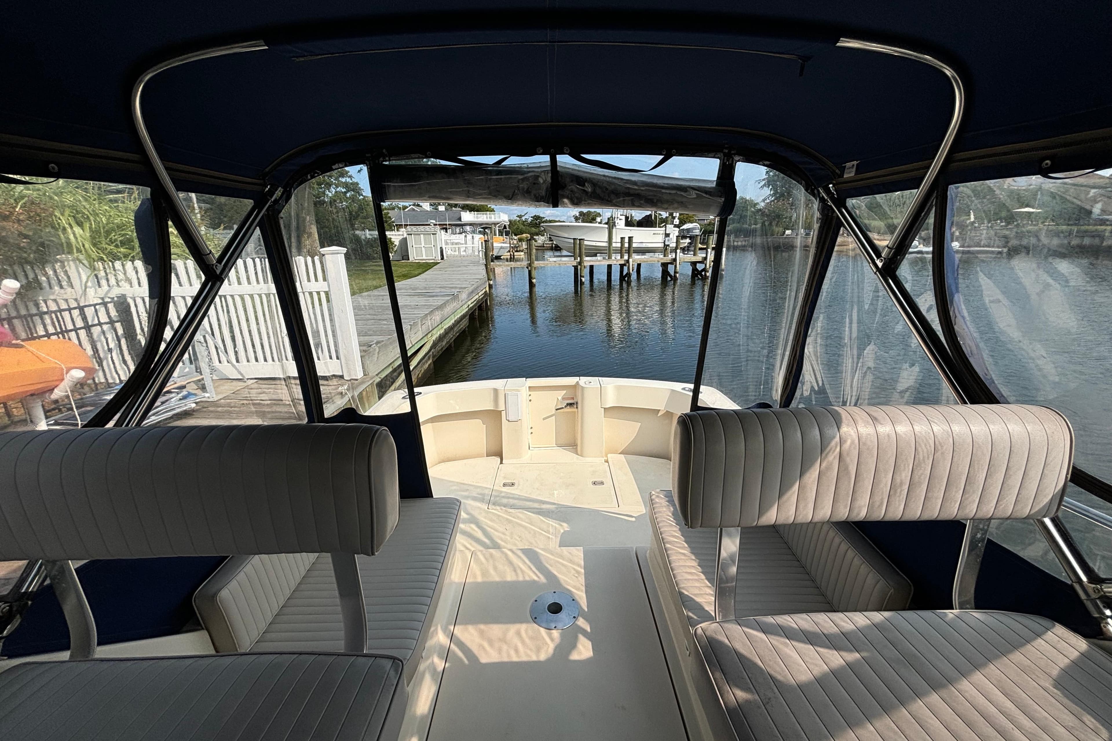 2005 Mainship Pilot 30-II Sedan interior with dockside view and cushioned seating.