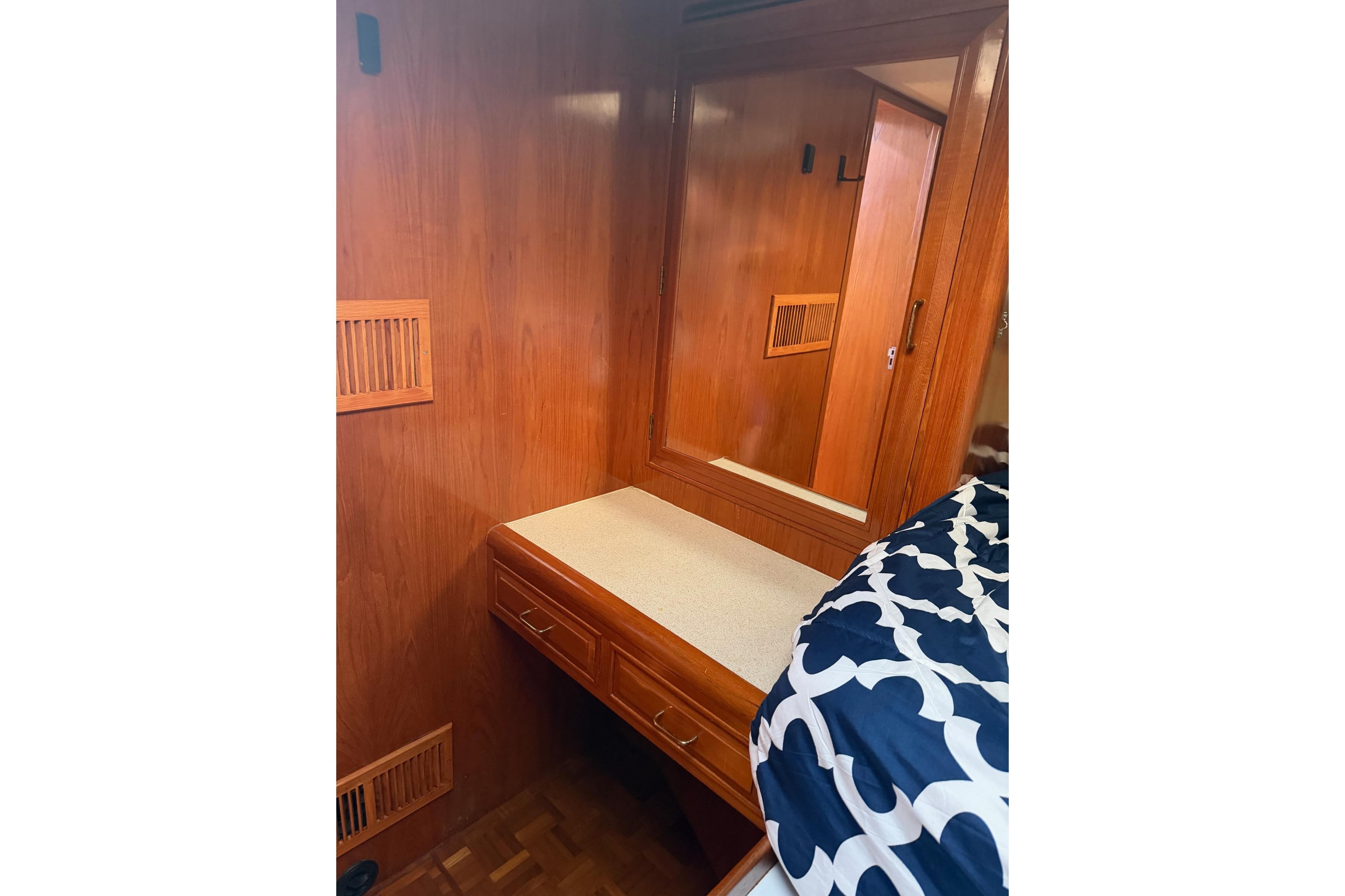 1988 Ocean Alexander 42' yacht interior with wooden cabinetry and cozy bedding.
