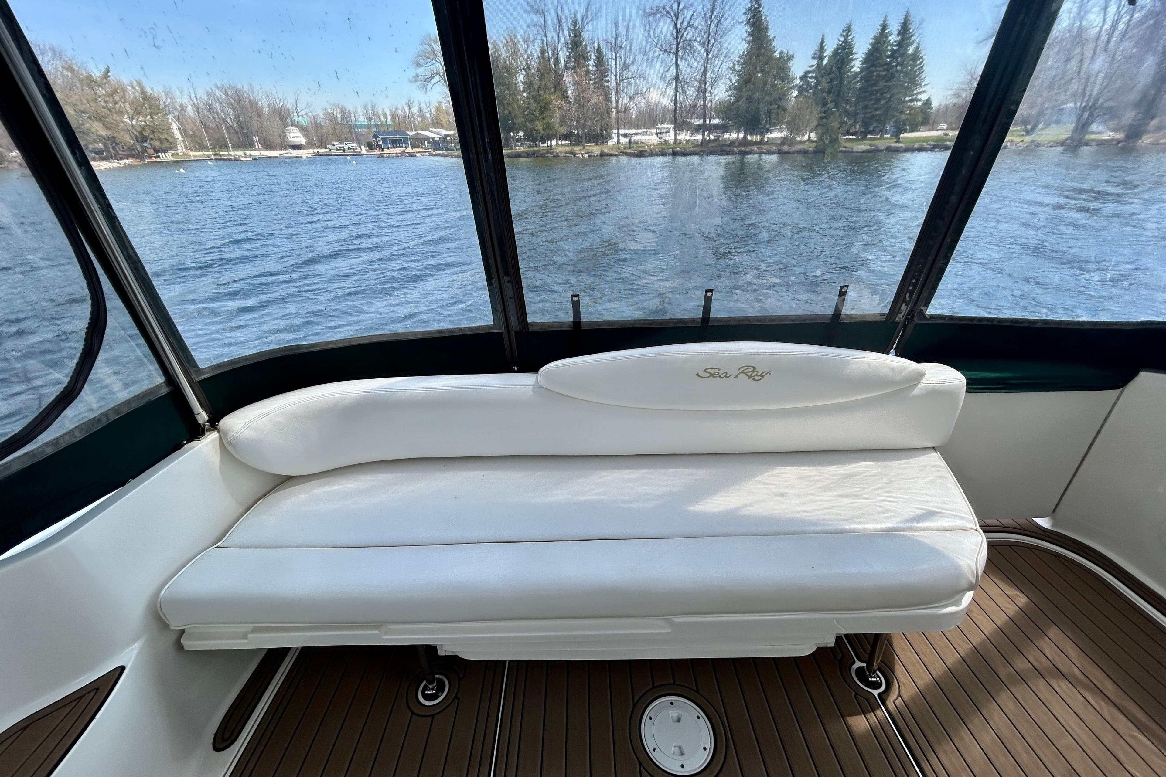 2002 Sea Ray 340 Sundancer boat interior with white seating and lake view.