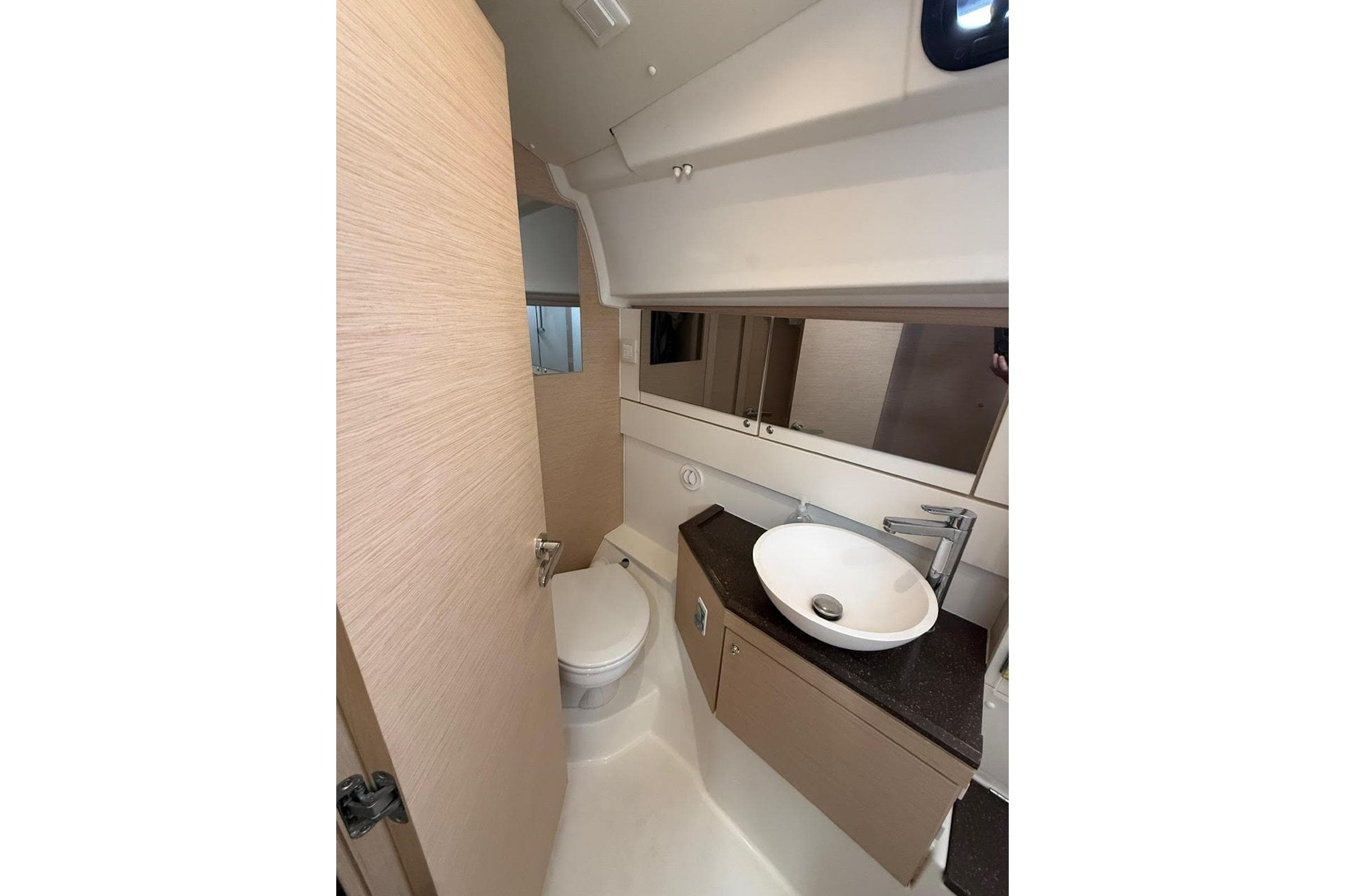 Modern bathroom interior of 2018 Jeanneau 51 yacht, featuring sleek sink and compact design.