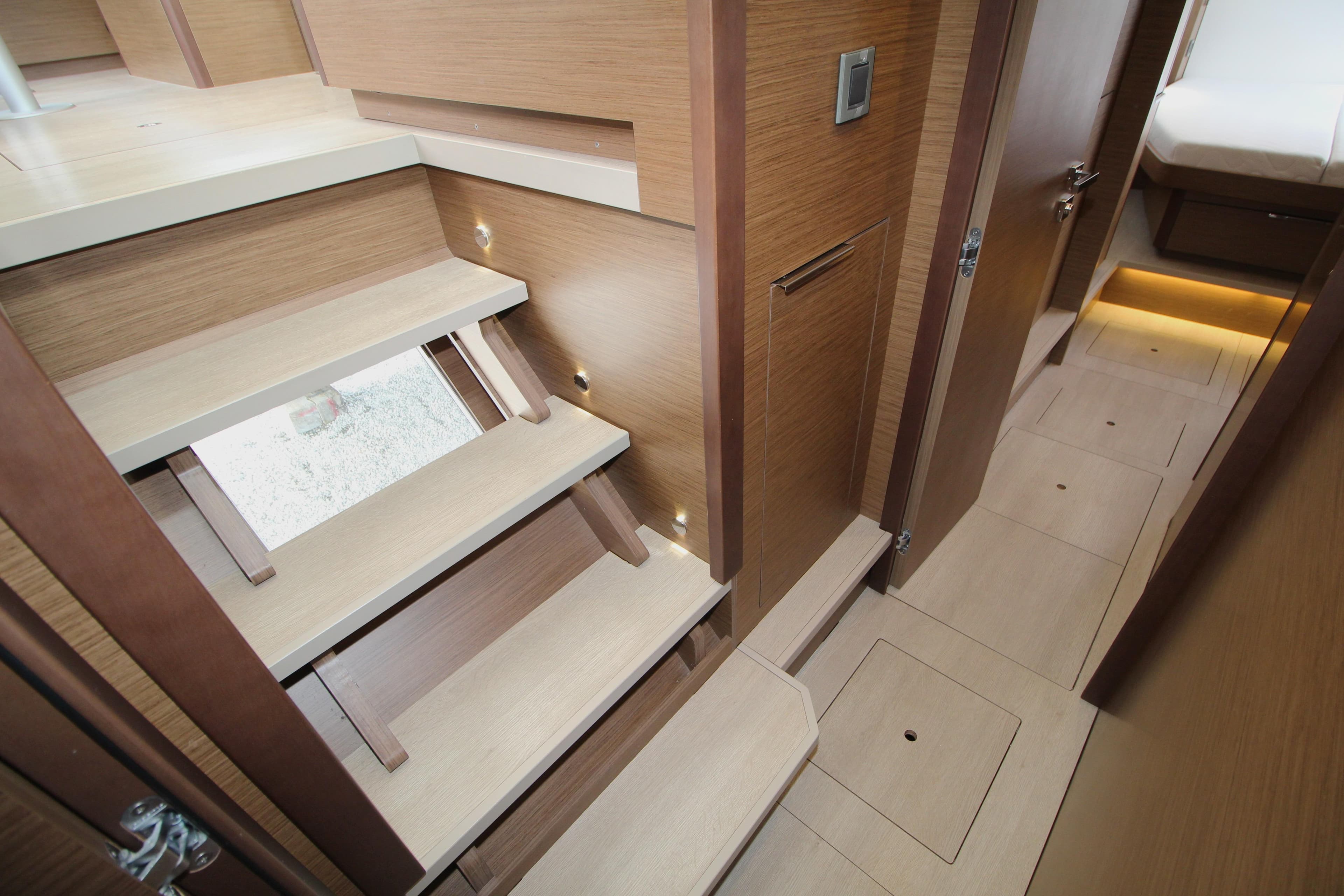 Interior of 2021 Lagoon 46 yacht, featuring wooden stairs and modern design elements.