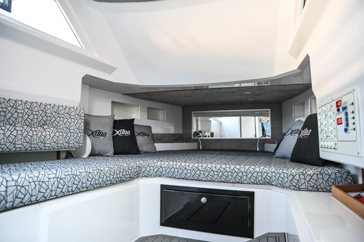 Modern DNA 46 boat interior, 2025 model, featuring a spacious cabin with patterned cushions and control panel.