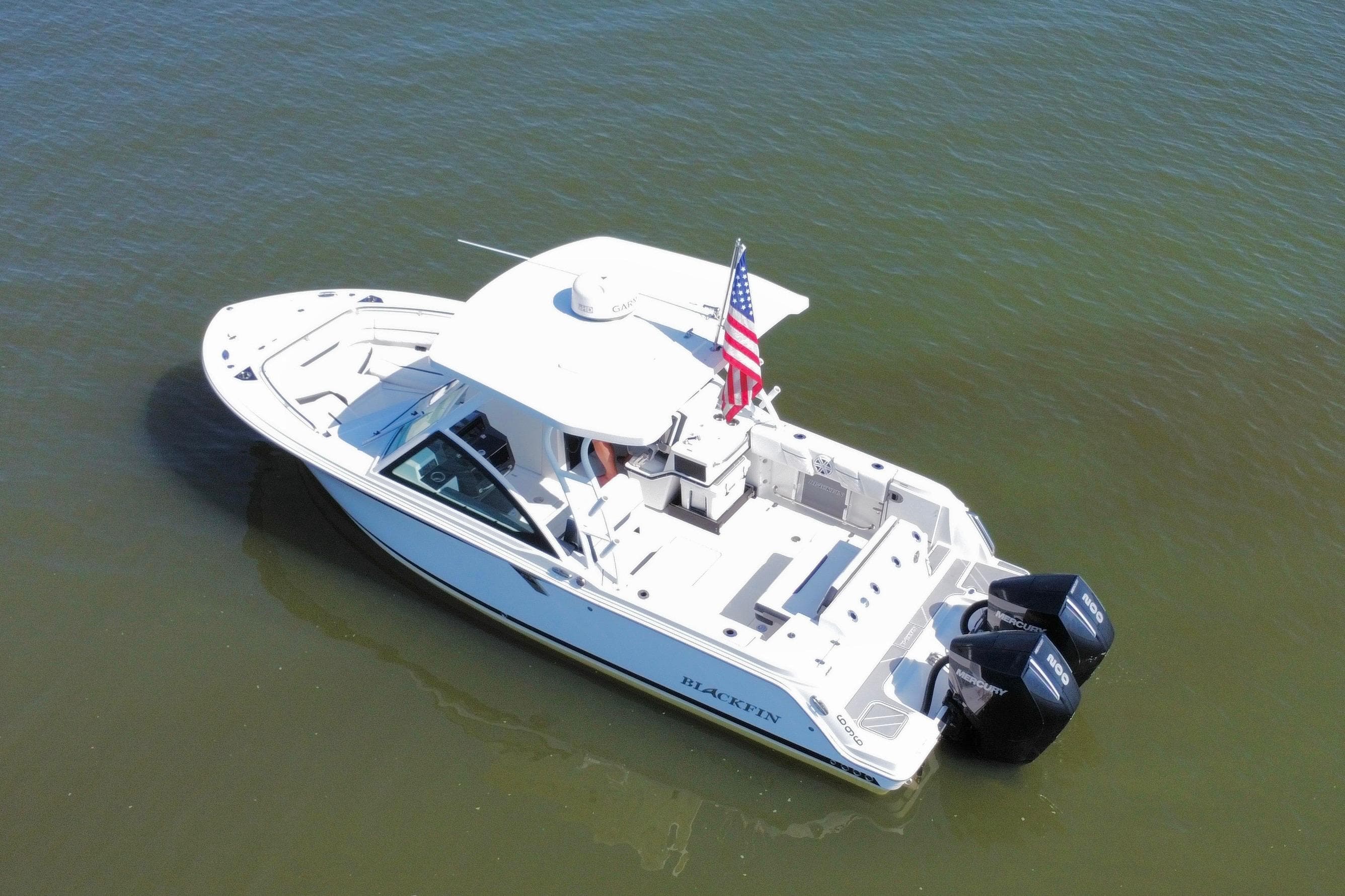 2021 Blackfin 252 DC boat with dual engines, American flag, on calm water.