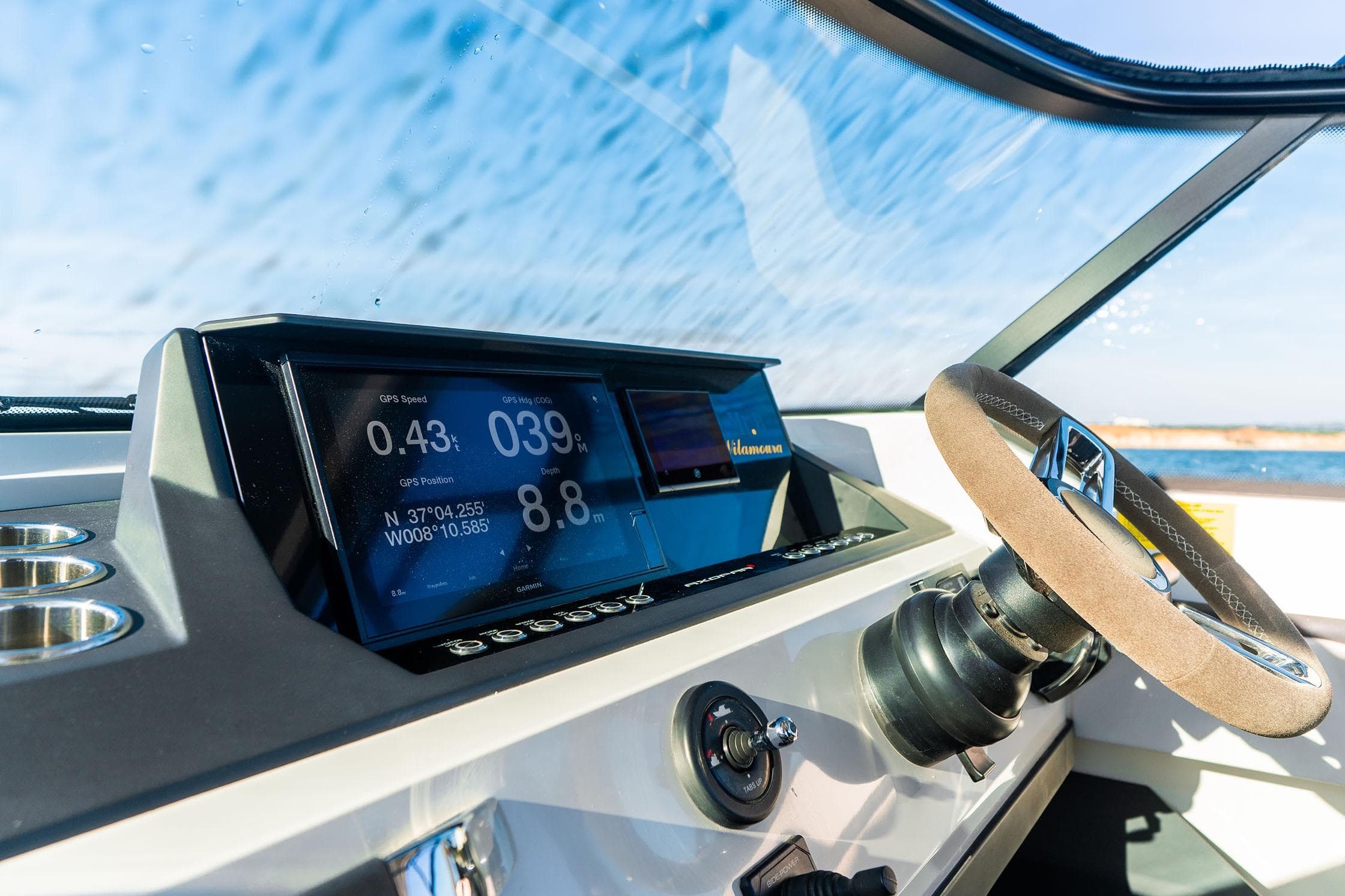 2019 Axopar 28 T-Top boat dashboard with GPS display and steering wheel.