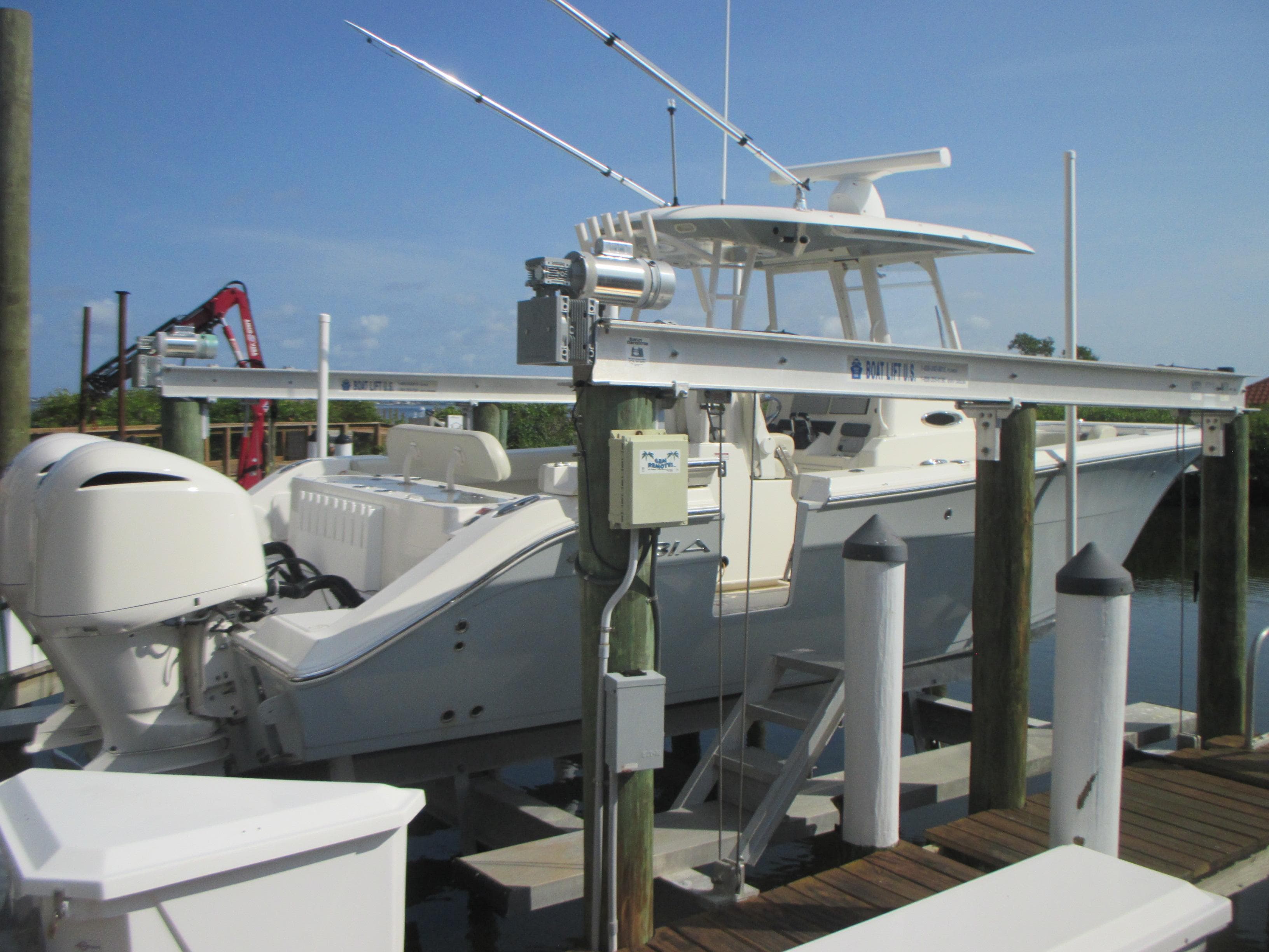 2018 Cobia 301 Center Console boat docked with fishing rods and twin engines.